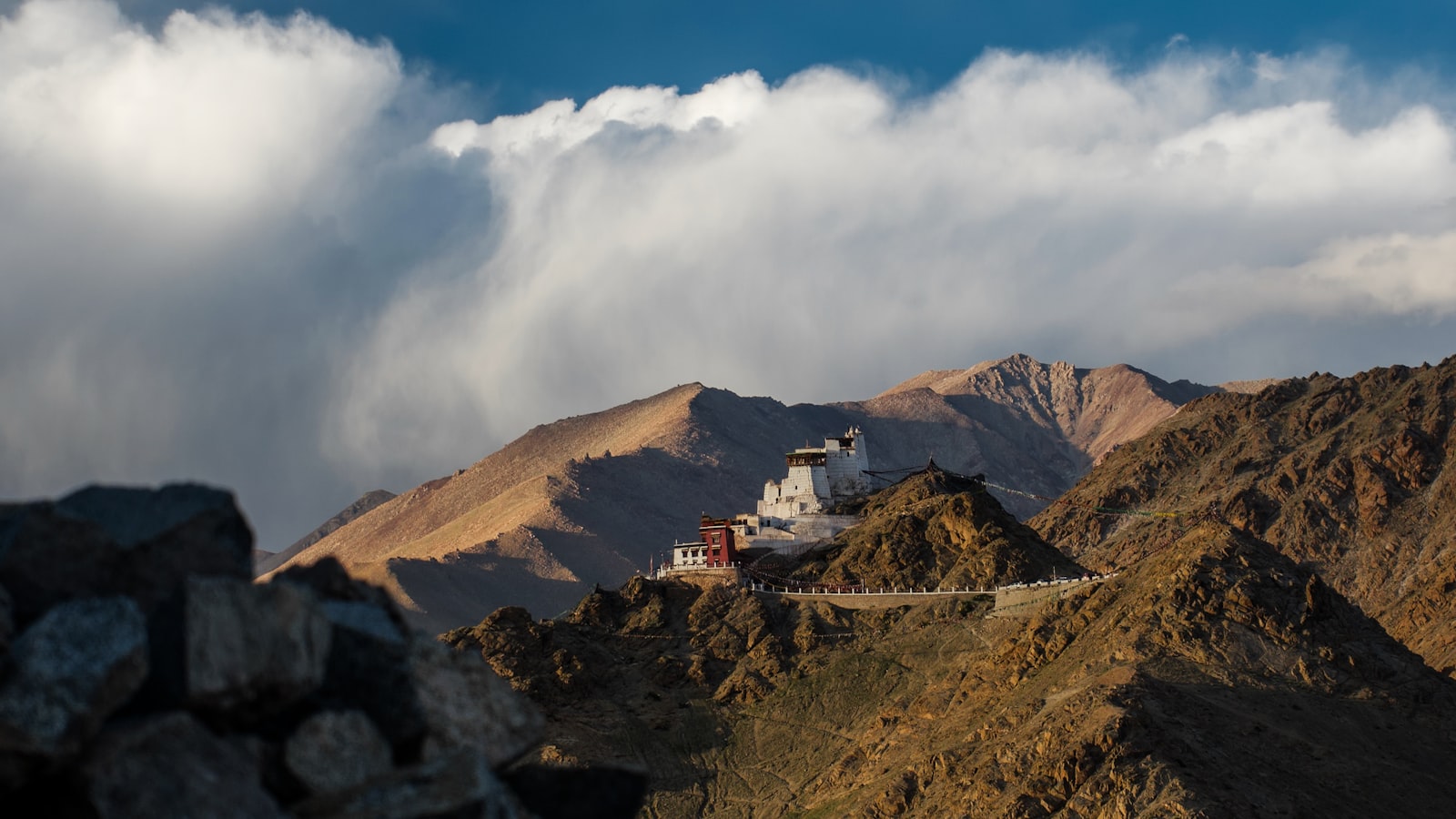 A monastery on a ridge in Ladakh, with cloud rolling behind the peaks