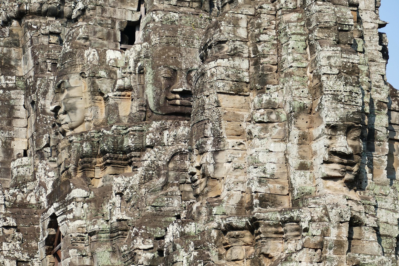 Two large serene faces carved into the weathered stone towers of the Bayon temple