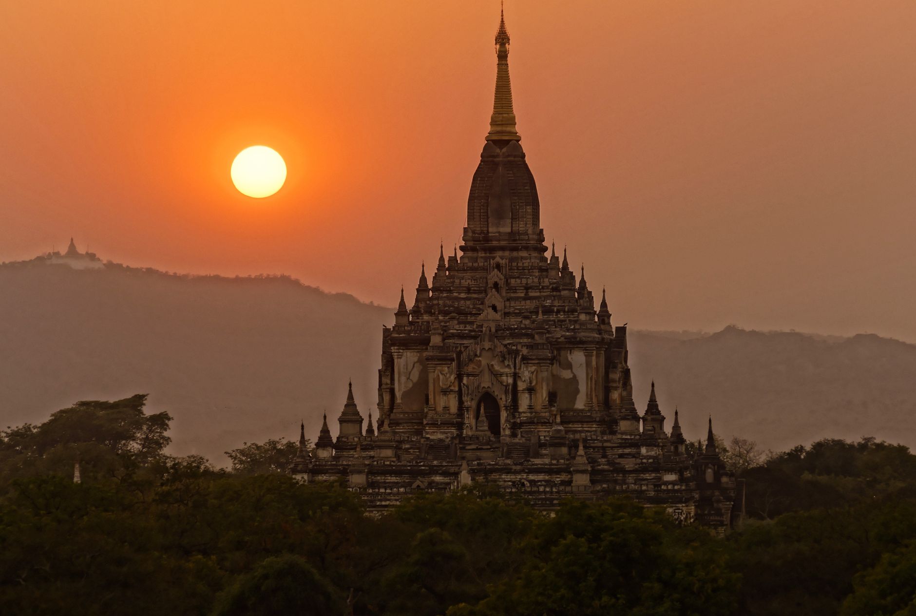 A Bagan temple silhouetted against a burning orange sky at sunset