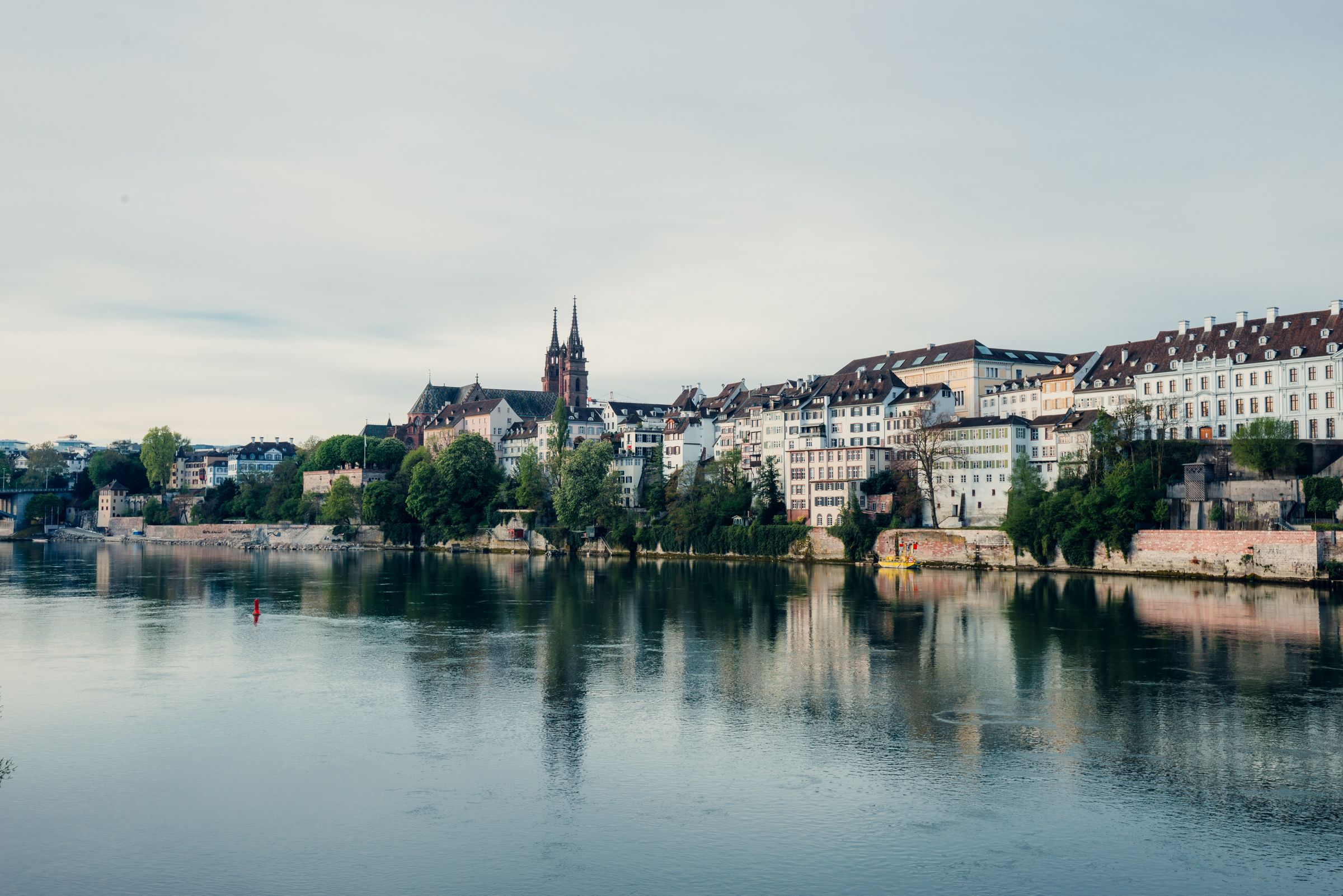 Grossbasel's riverfront houses along the Rhine, with the twin red towers of Basel Minster rising above the roofs