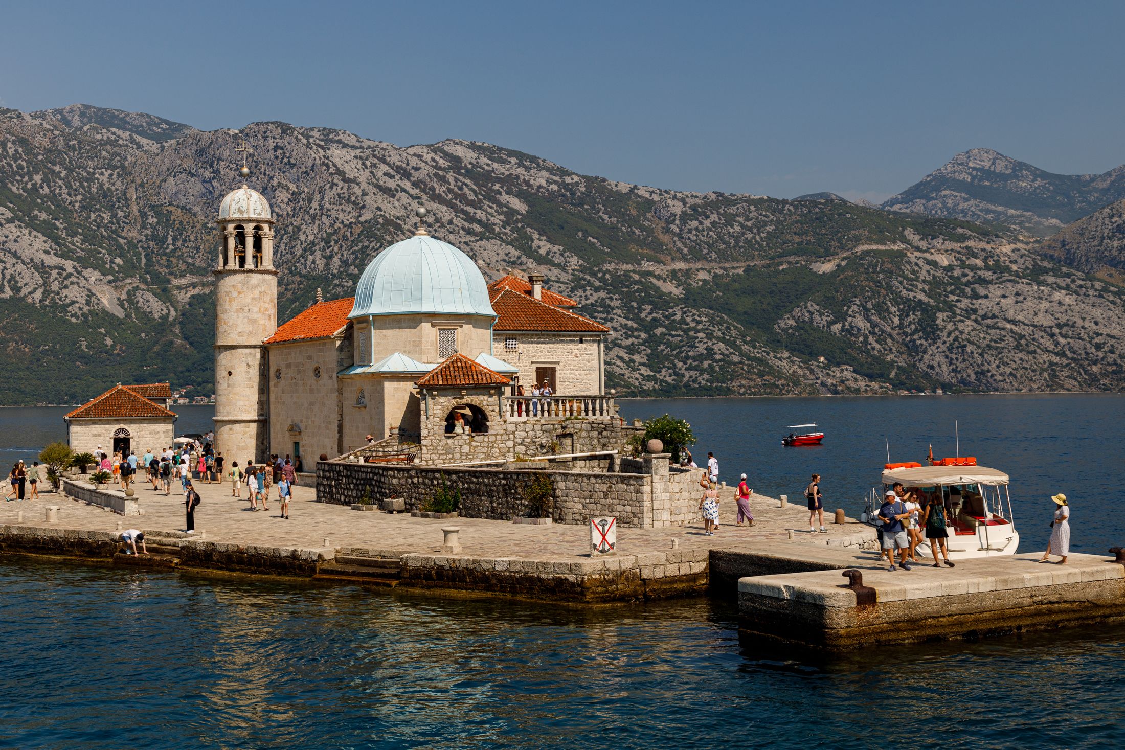 The island church of Our Lady of the Rocks on its man-made island in the Bay of Kotor, mountains behind