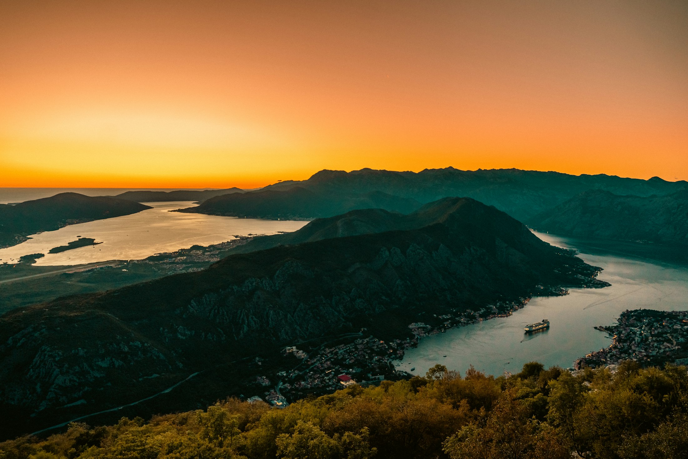 Golden sunset over the winding Bay of Kotor seen from above, the mountains in silhouette
