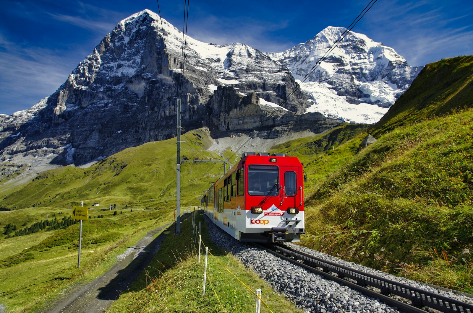 A red cog railway train below the Eiger and Monch
