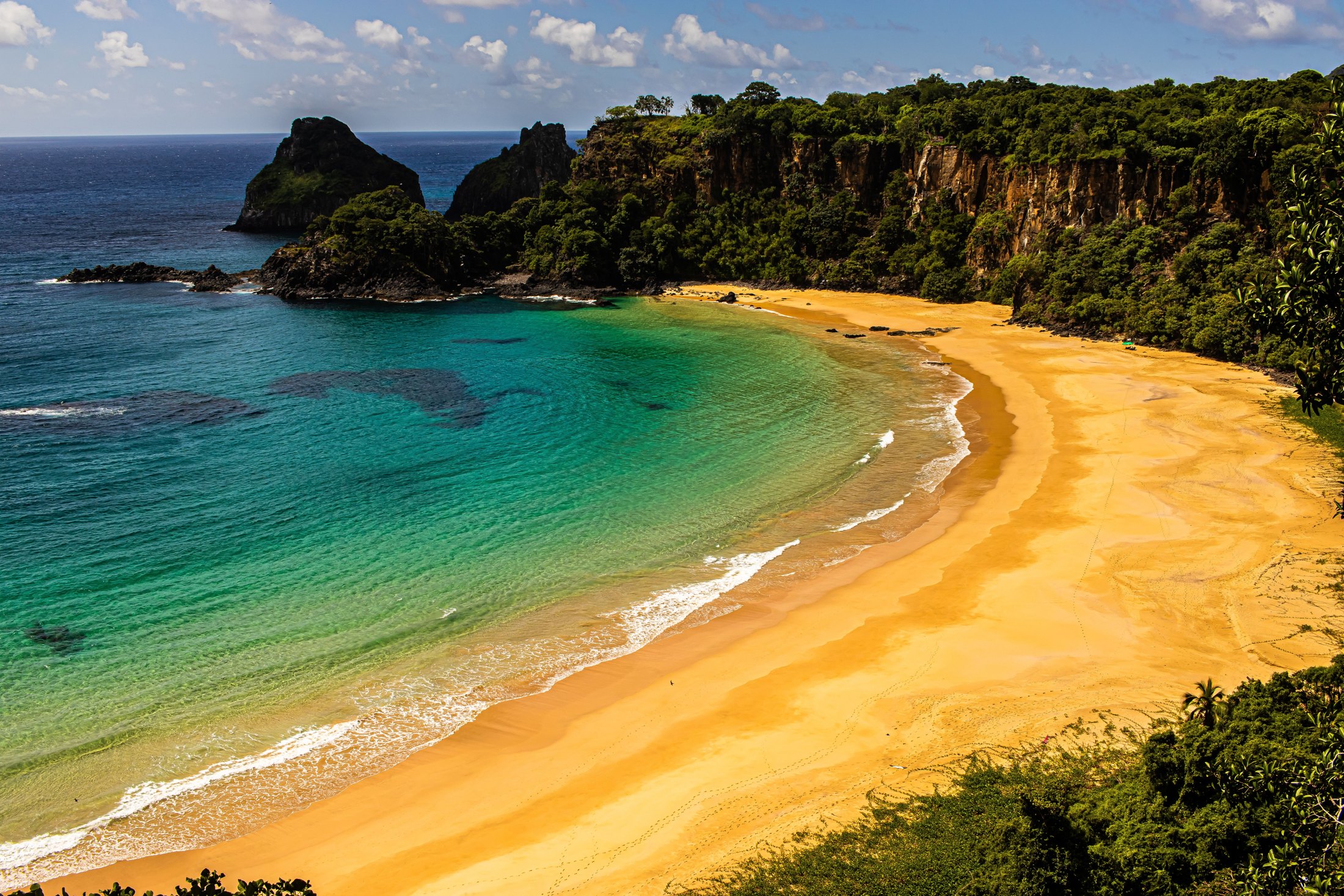 Baía do Sancho from the cliff above, a curve of sand between headlands and turquoise water
