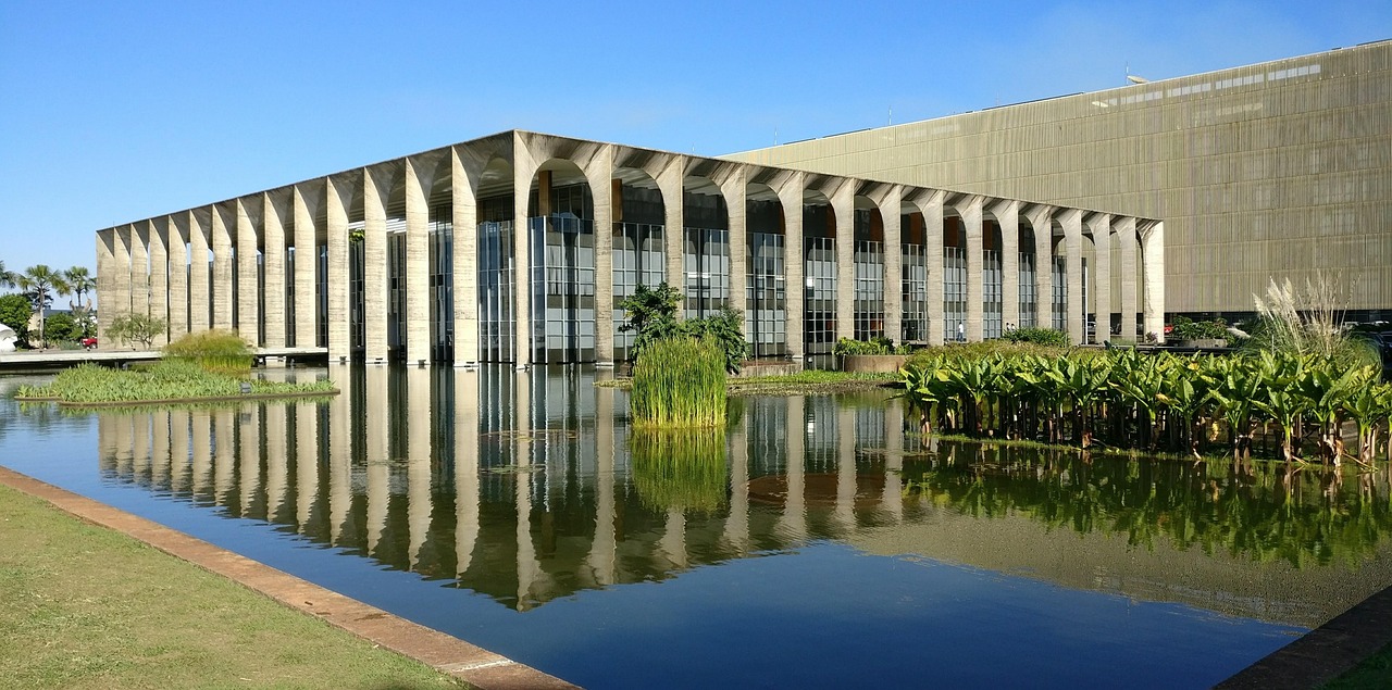 The tall concrete arches of the Itamaraty Palace rising from its reflecting pool in Brasília, with Burle Marx planting on the water