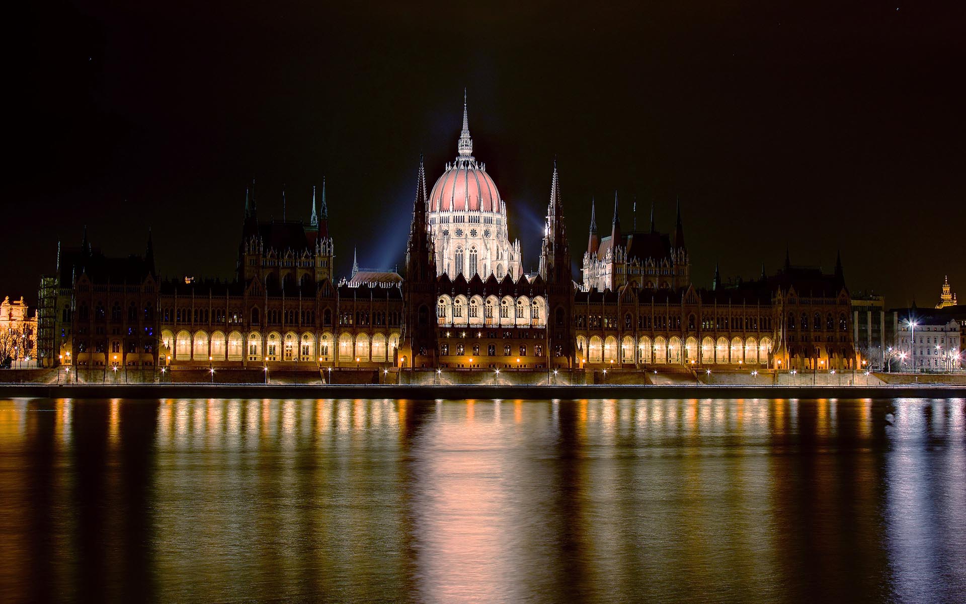 The Hungarian Parliament Building illuminated at night above the Danube