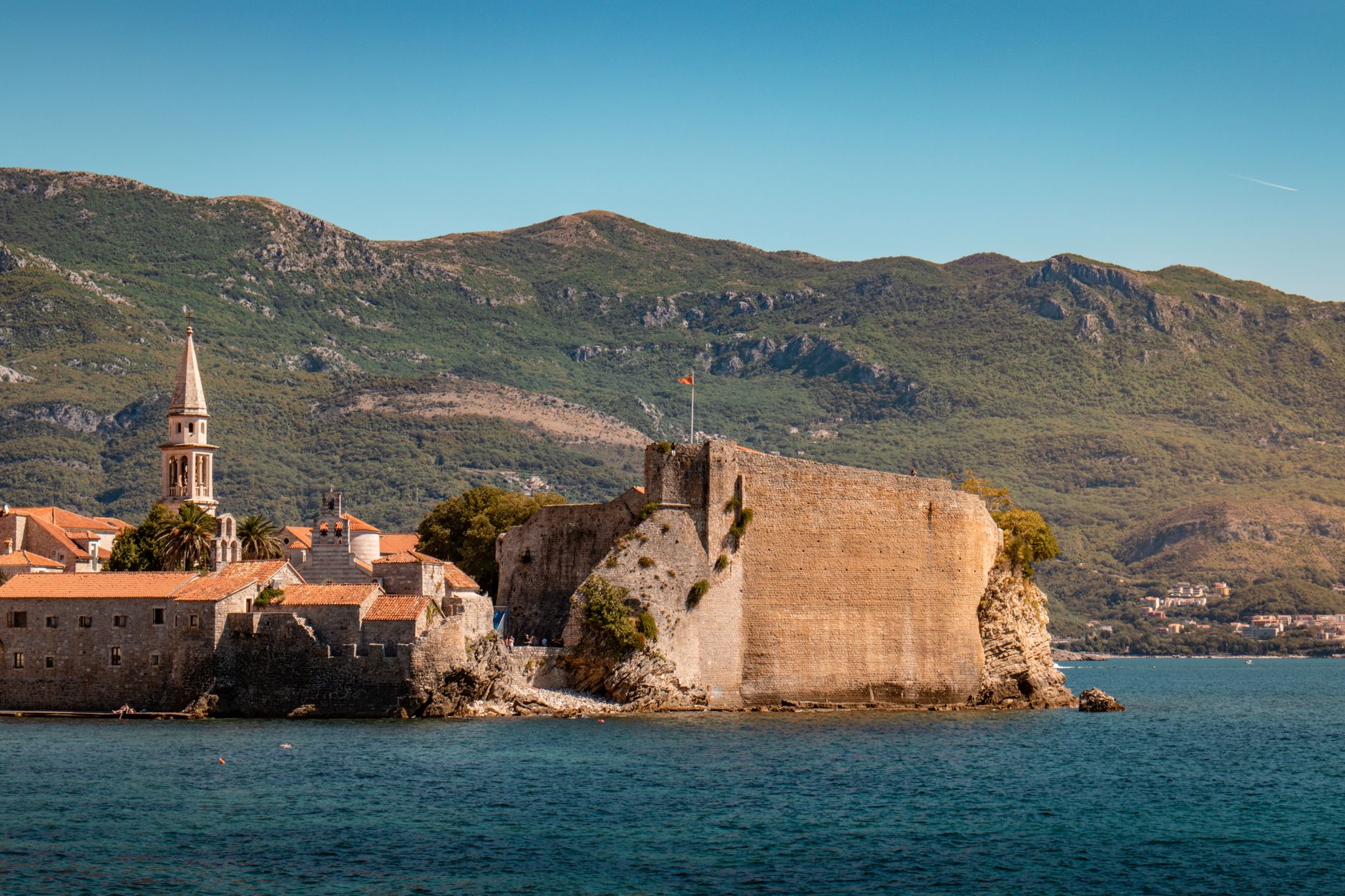 The seaward rampart of Budva's citadel rising from the rock, with the campanile of St John's behind and mountains beyond