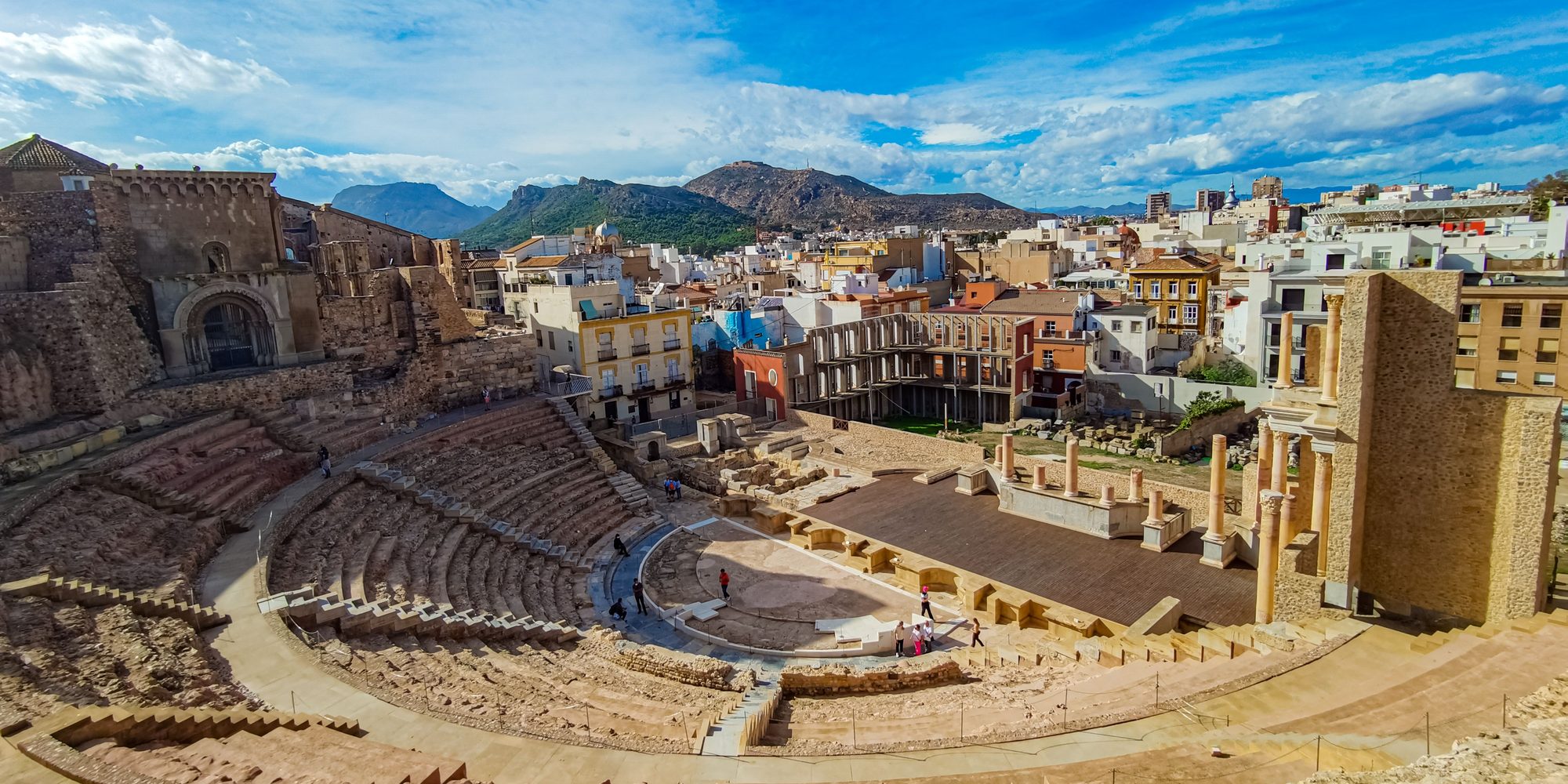The Roman Theatre of Cartagena from the upper seats, the ruined cathedral on the left, the stage columns on the right and the town and hills behind