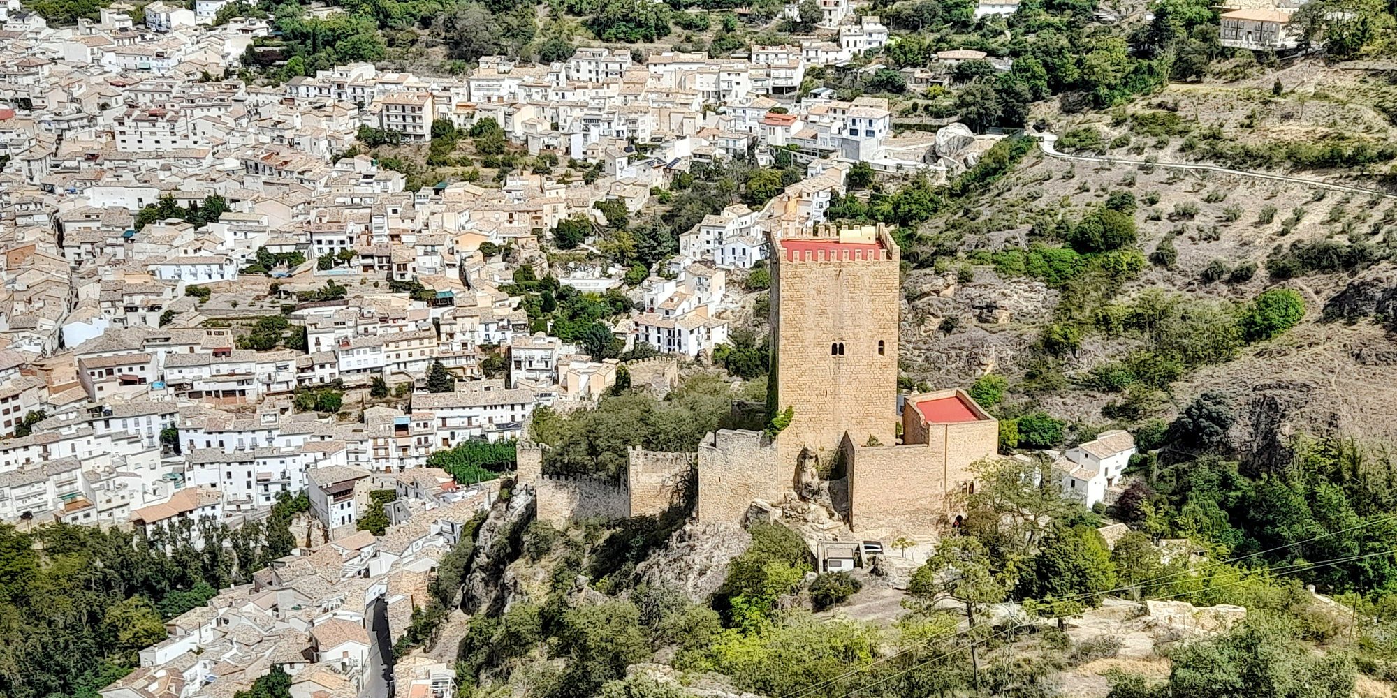 The square keep of the Castillo de la Yedra on its rocky spur, with the white houses of Cazorla climbing the hillside behind it