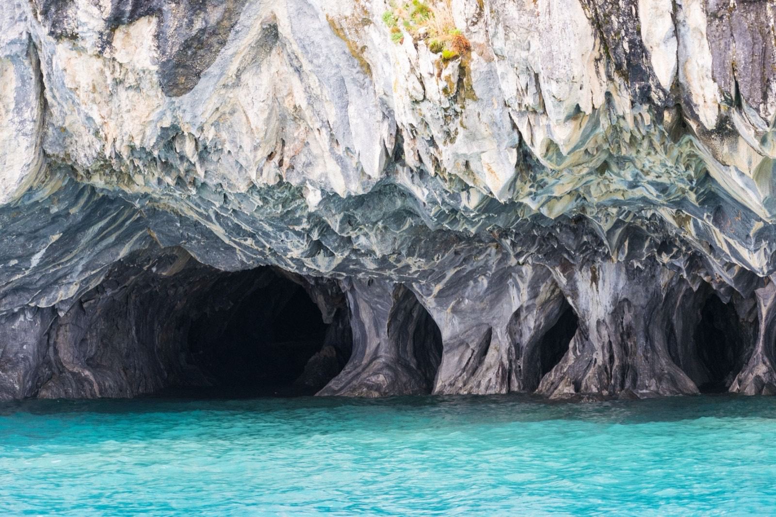 The Marble Caves on Lago General Carrera, grey and white veined rock hollowed into arches over turquoise water