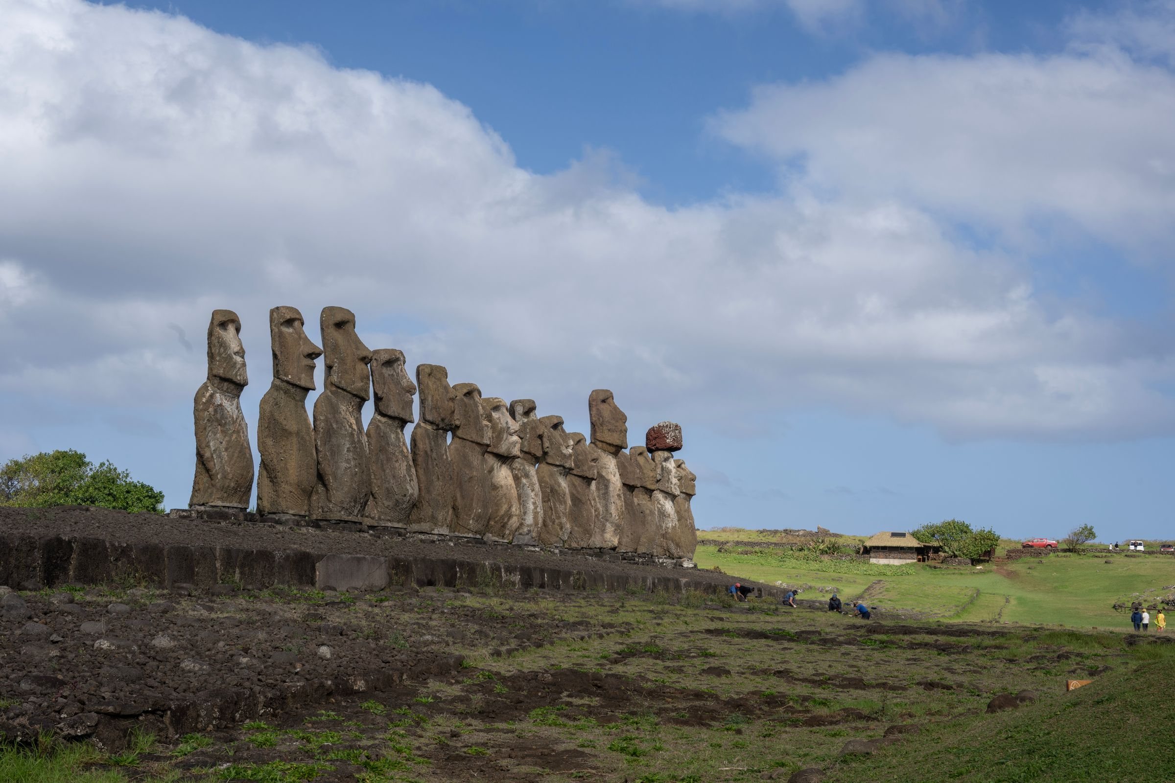 The fifteen restored moai of Ahu Tongariki standing in a row on their platform under a blue sky on Rapa Nui