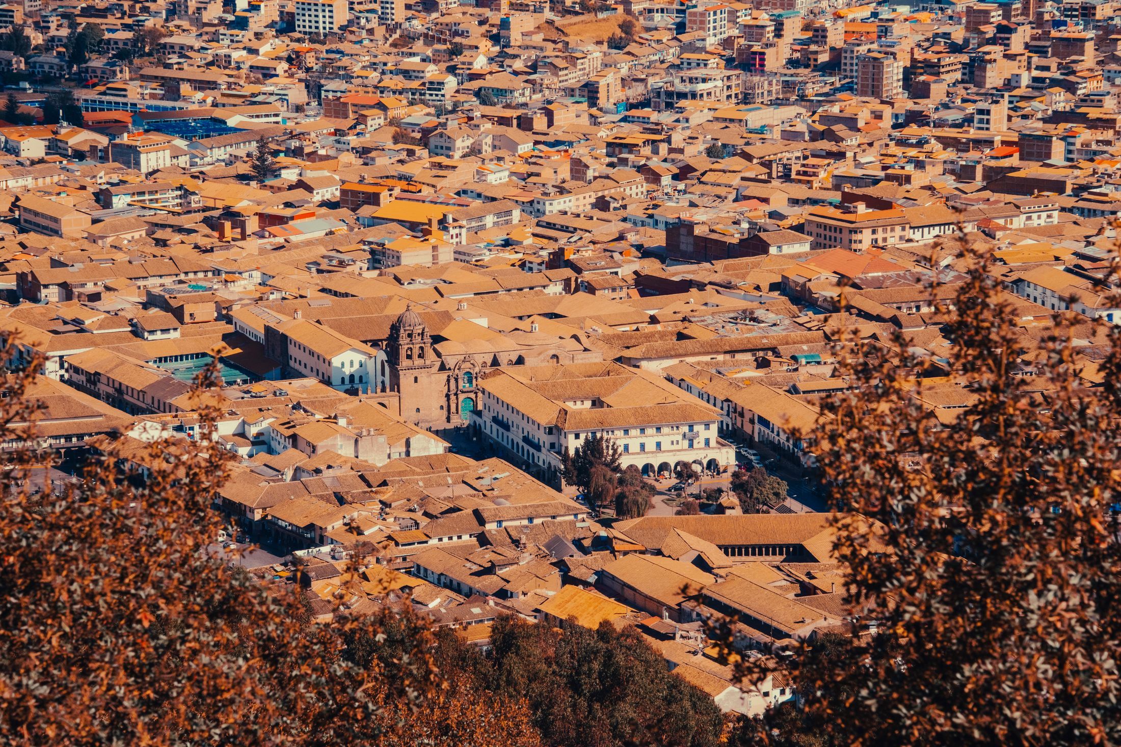 An aerial view of Cusco's terracotta rooftops and central plaza in the Peruvian Andes