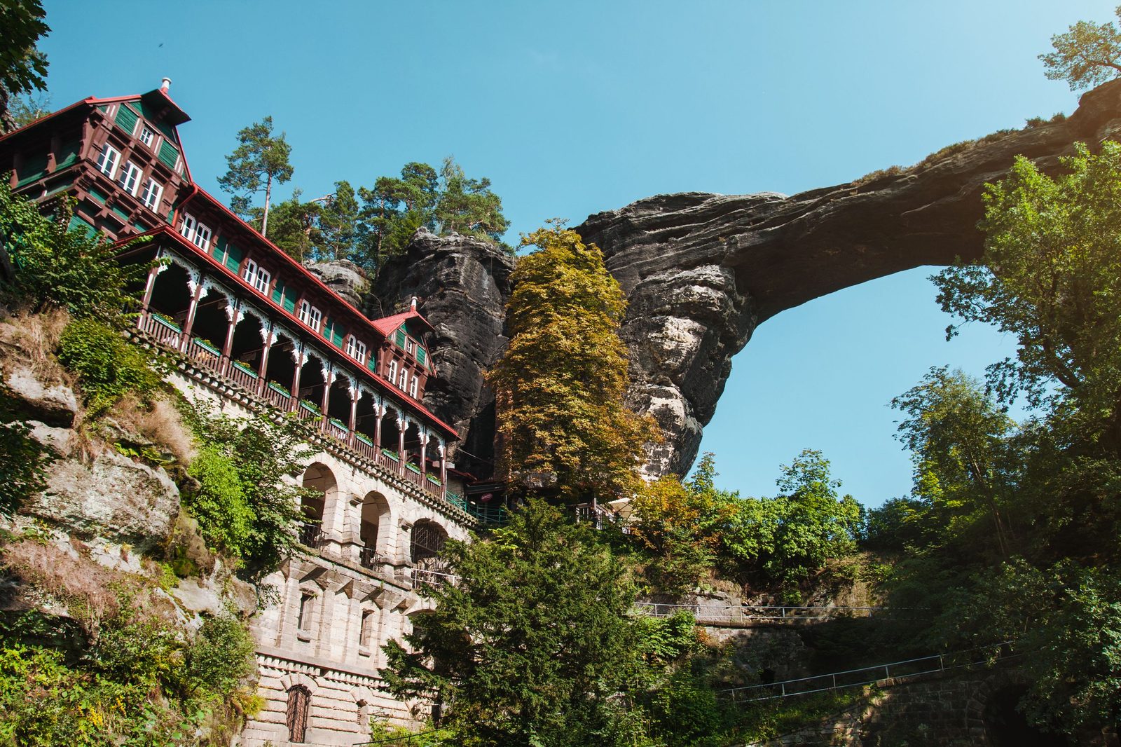 The Pravčická brána sandstone arch beside the Falcon’s Nest, a timber-framed house built into the rock below it, in Bohemian Switzerland