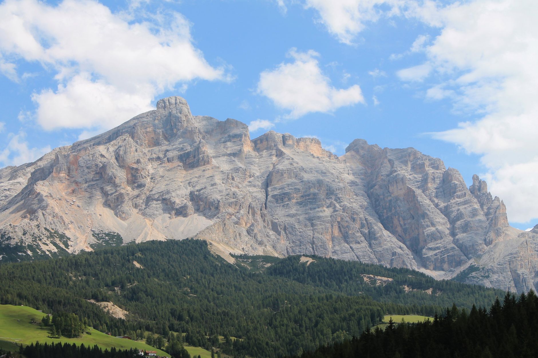 Pale Dolomite massif rising above dark forested slopes in Alta Badia