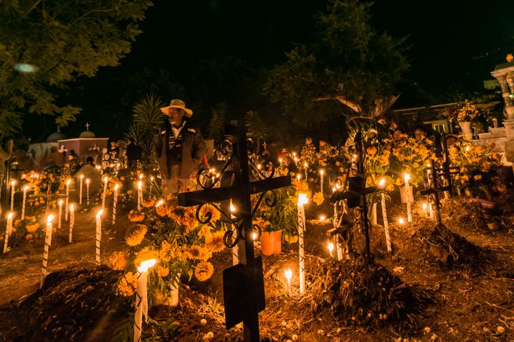 Candles lit on graves at night during Día de Muertos in Santa María Atzompa, Oaxaca