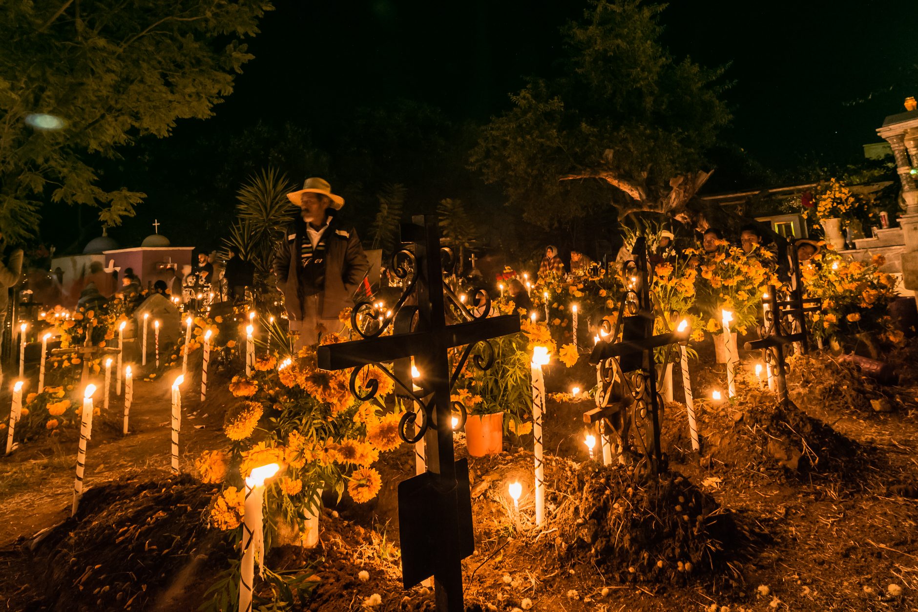 Candles lit on graves at night during Día de Muertos in Santa María Atzompa, Oaxaca