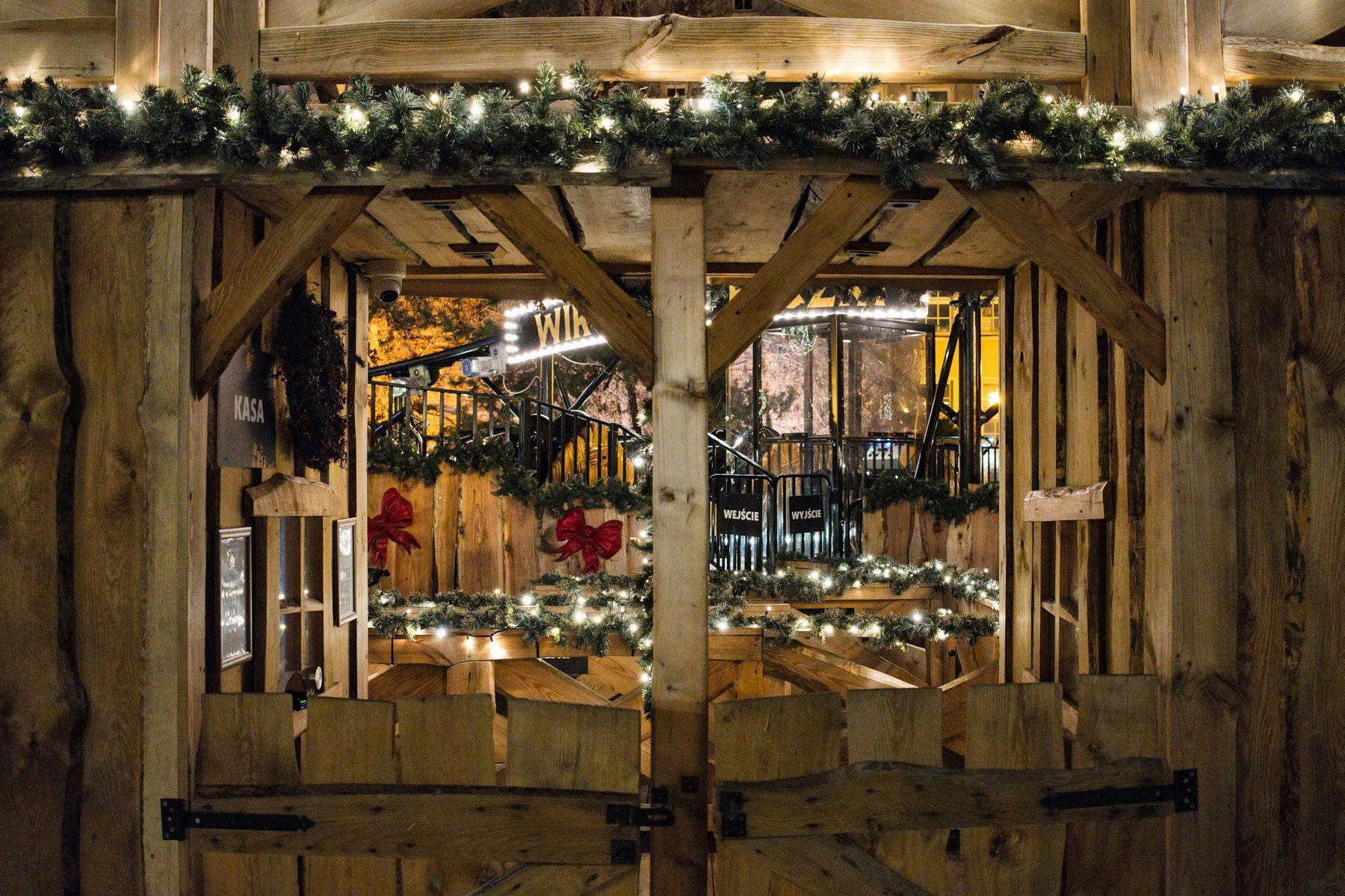 A rustic wooden market stall hung with Christmas lights