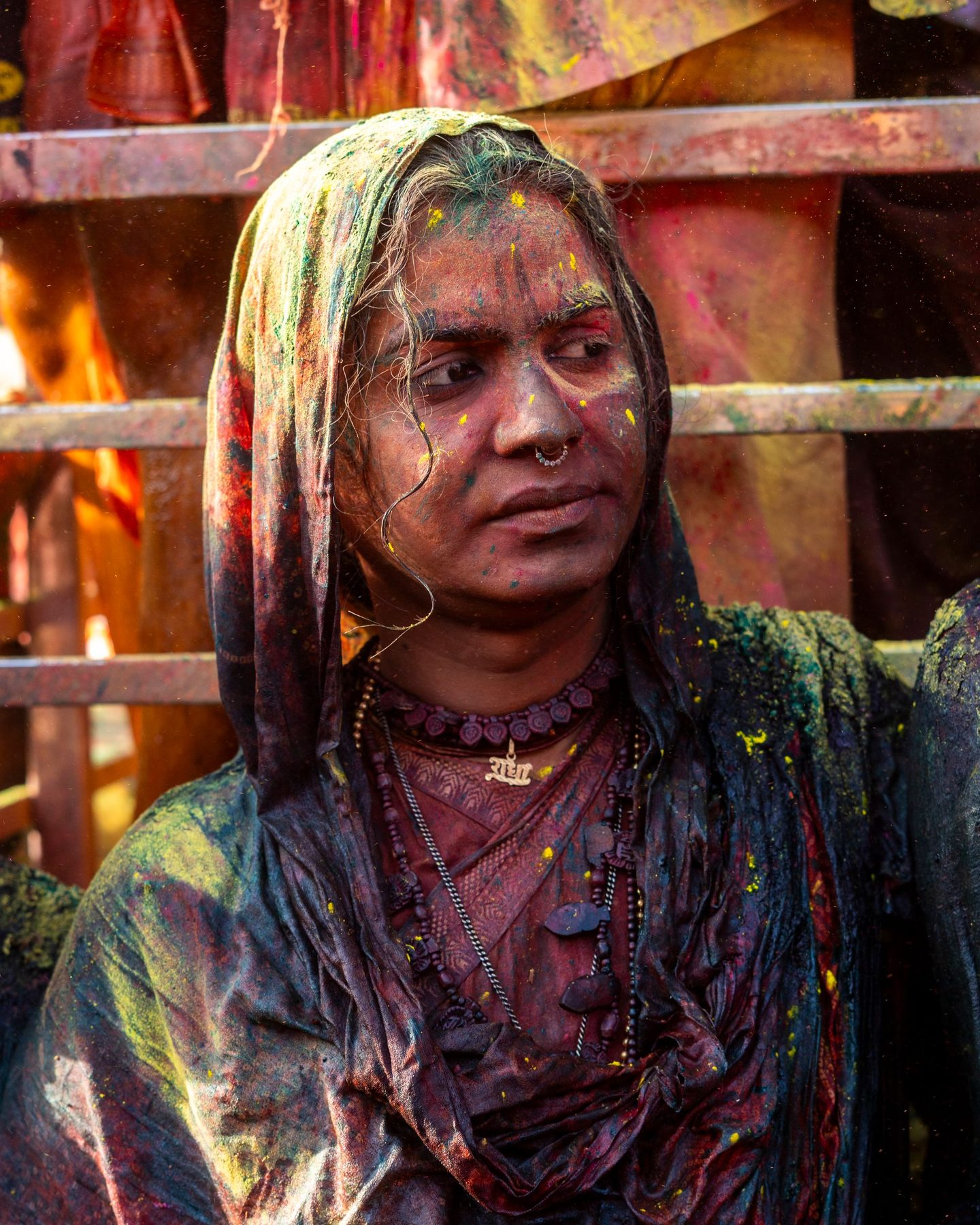 A woman in Nandgaon with her face and veil covered in coloured powder during Holi