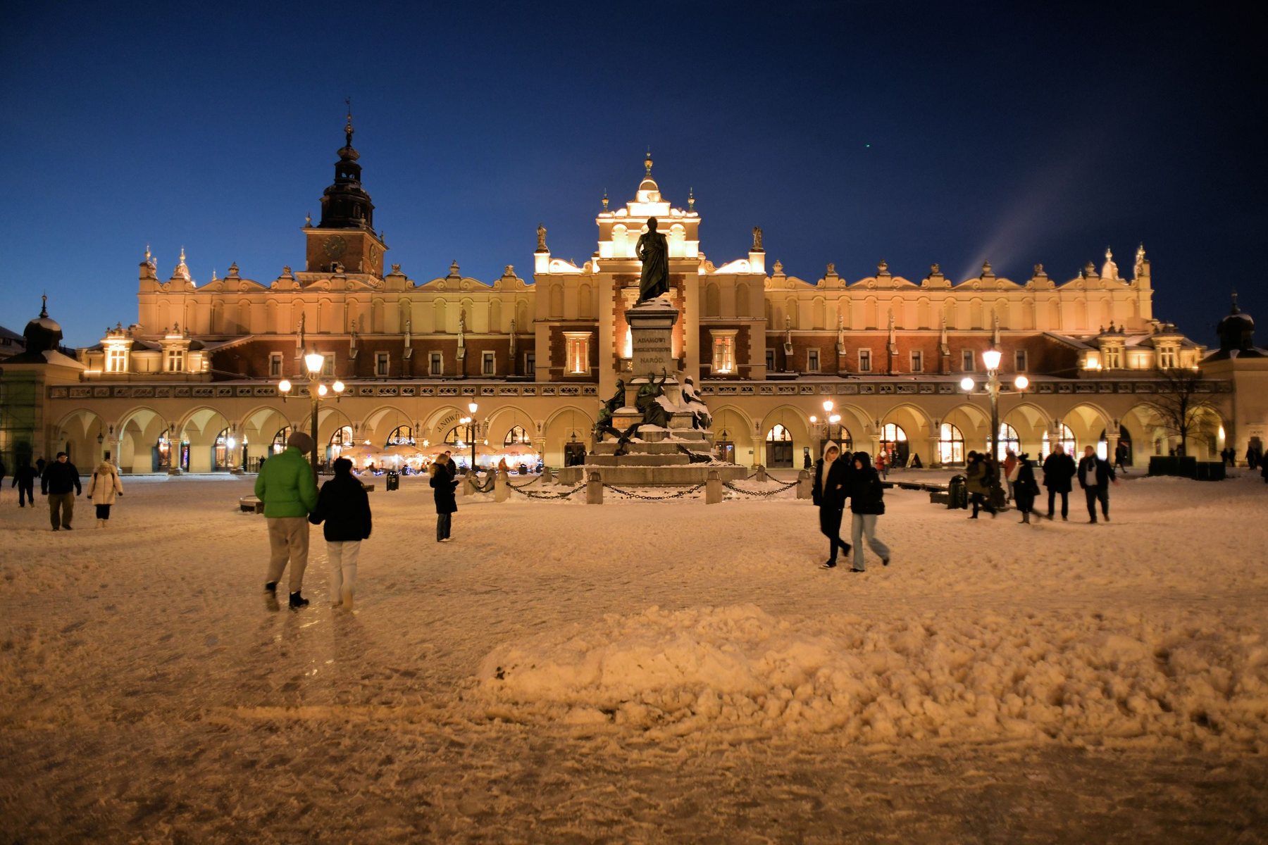 The Cloth Hall and the Adam Mickiewicz monument lit up on Kraków's main square on a snowy night