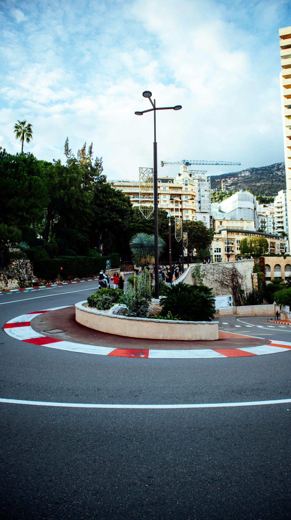 A red and white race kerb on a street corner in Monte Carlo, apartment blocks behind, on a day with no racing