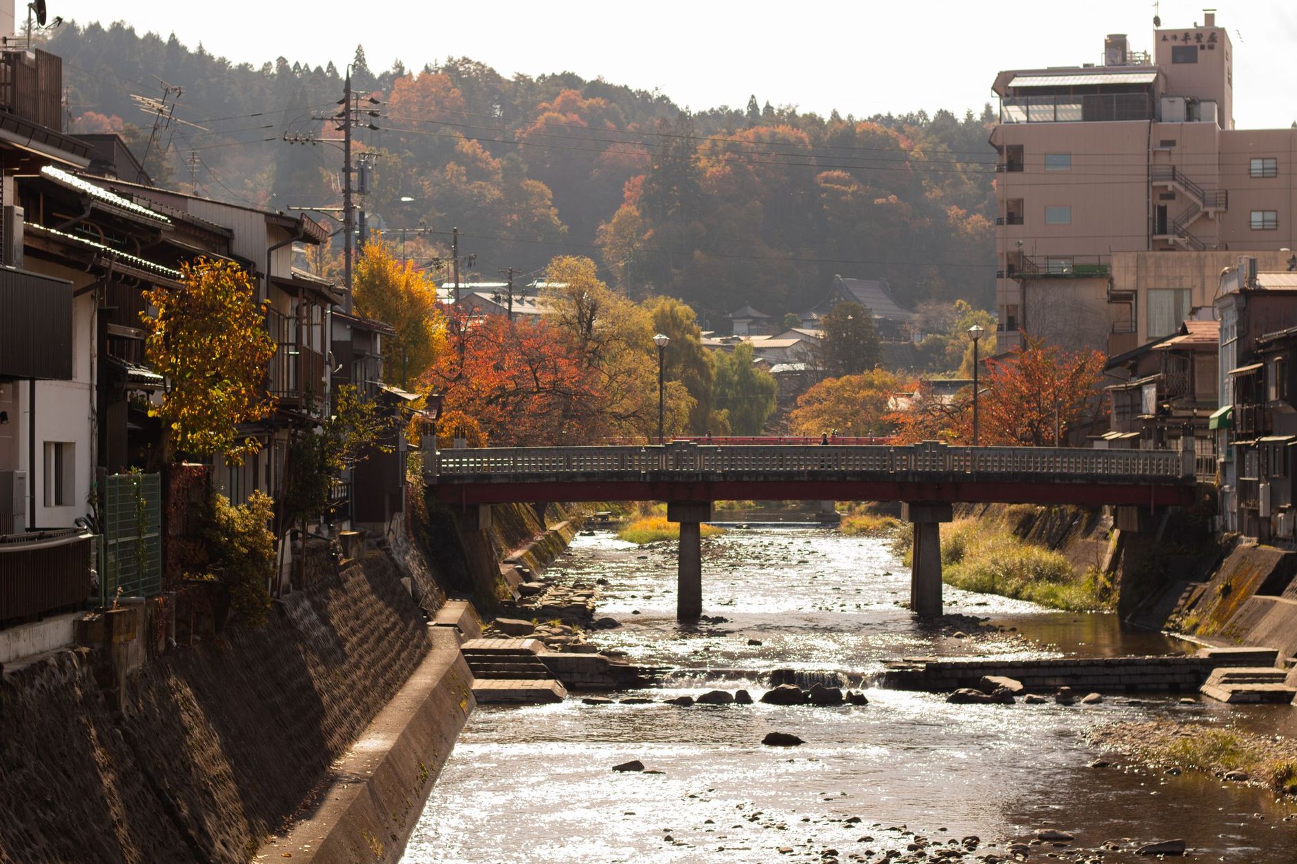 The Miyagawa river and the red Nakabashi bridge in Takayama in autumn