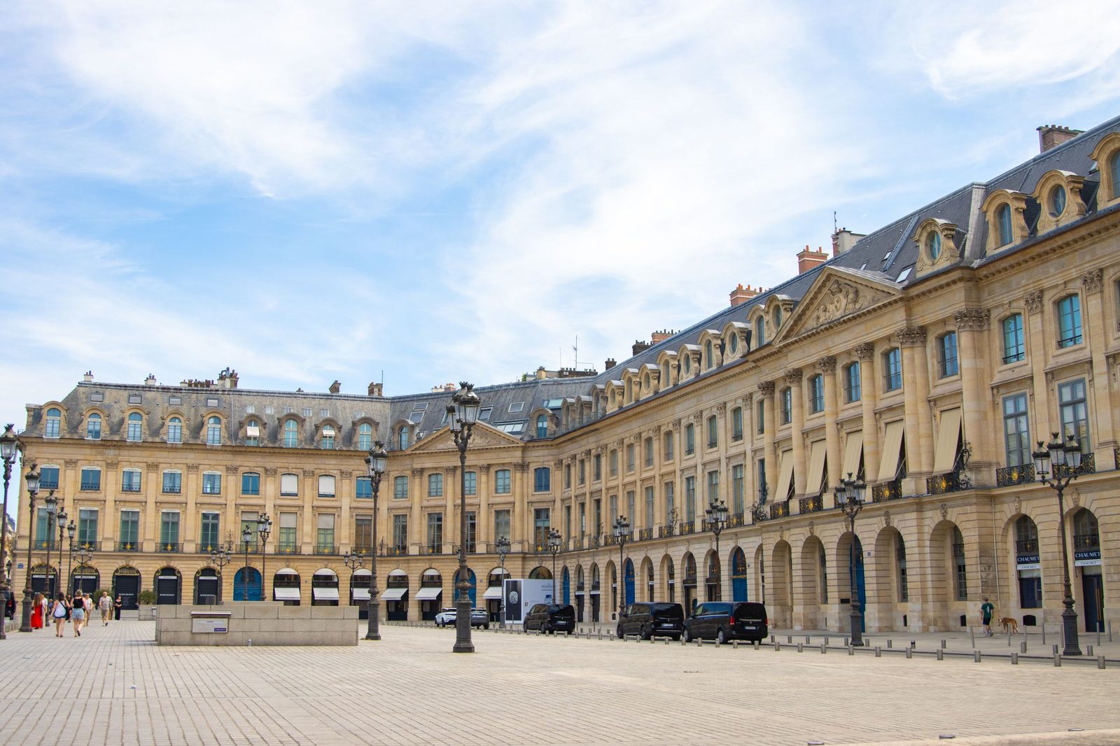 The Place Vendôme in Paris in daylight, its arcaded stone facades and the column at the centre of the square