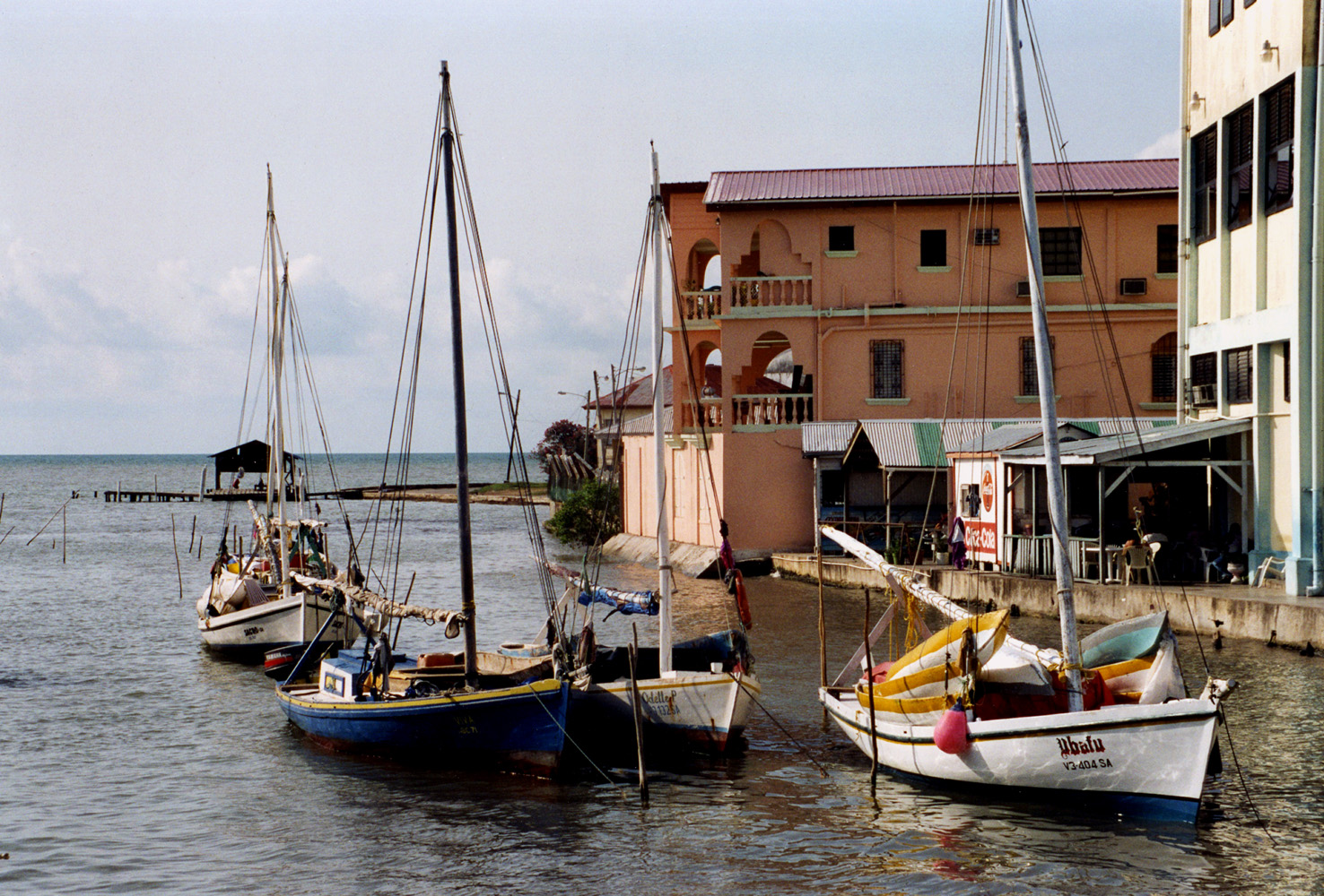 Traditional wooden sailing skiffs moored on the water at the Belize City waterfront