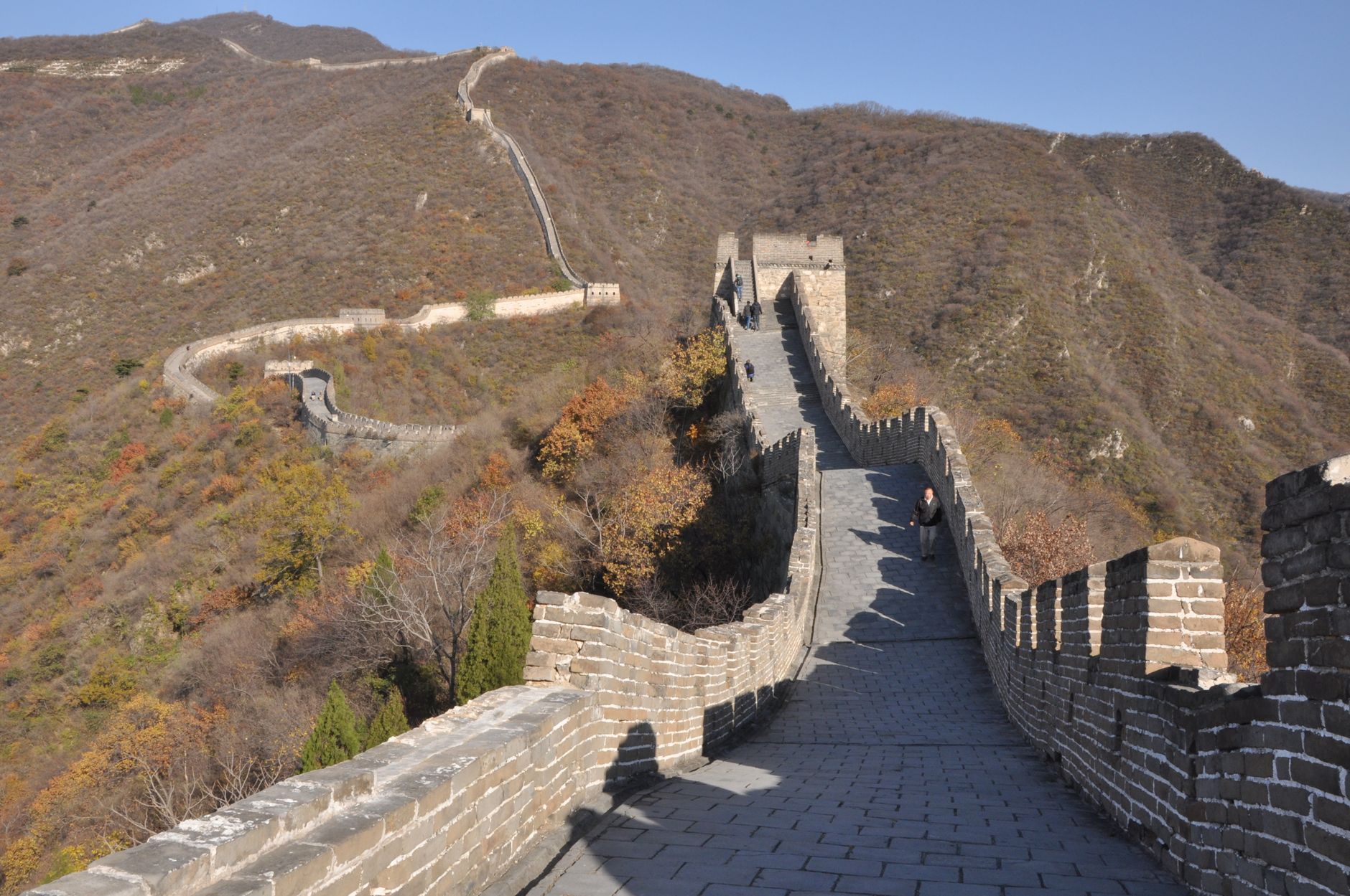 The Great Wall running across rolling hills covered in autumn colour