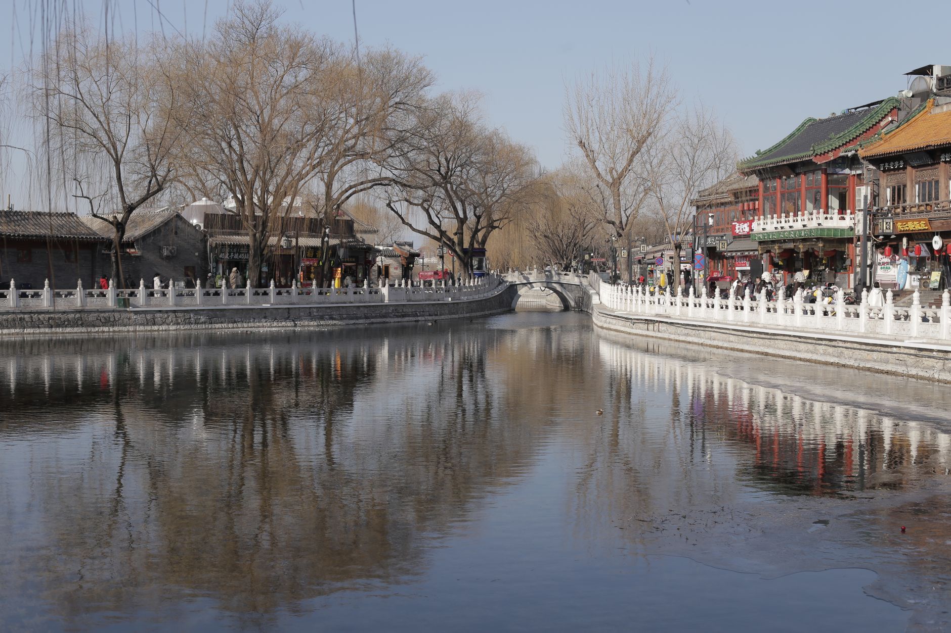 A canal and grey-tiled buildings in a reconstructed Chinese water town in winter