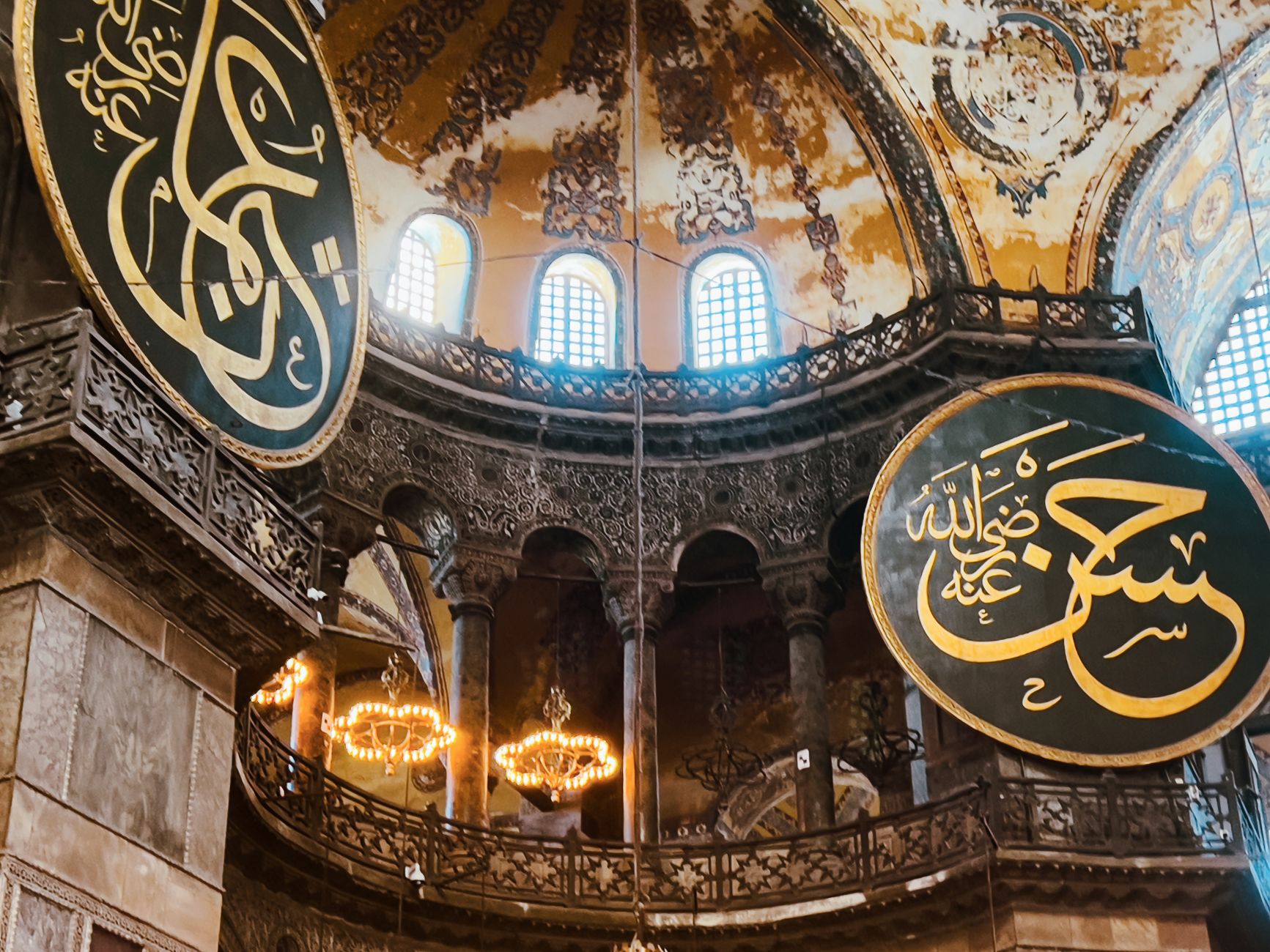 The gold Arabic calligraphy roundels of Hagia Sophia against the arches and half-domes