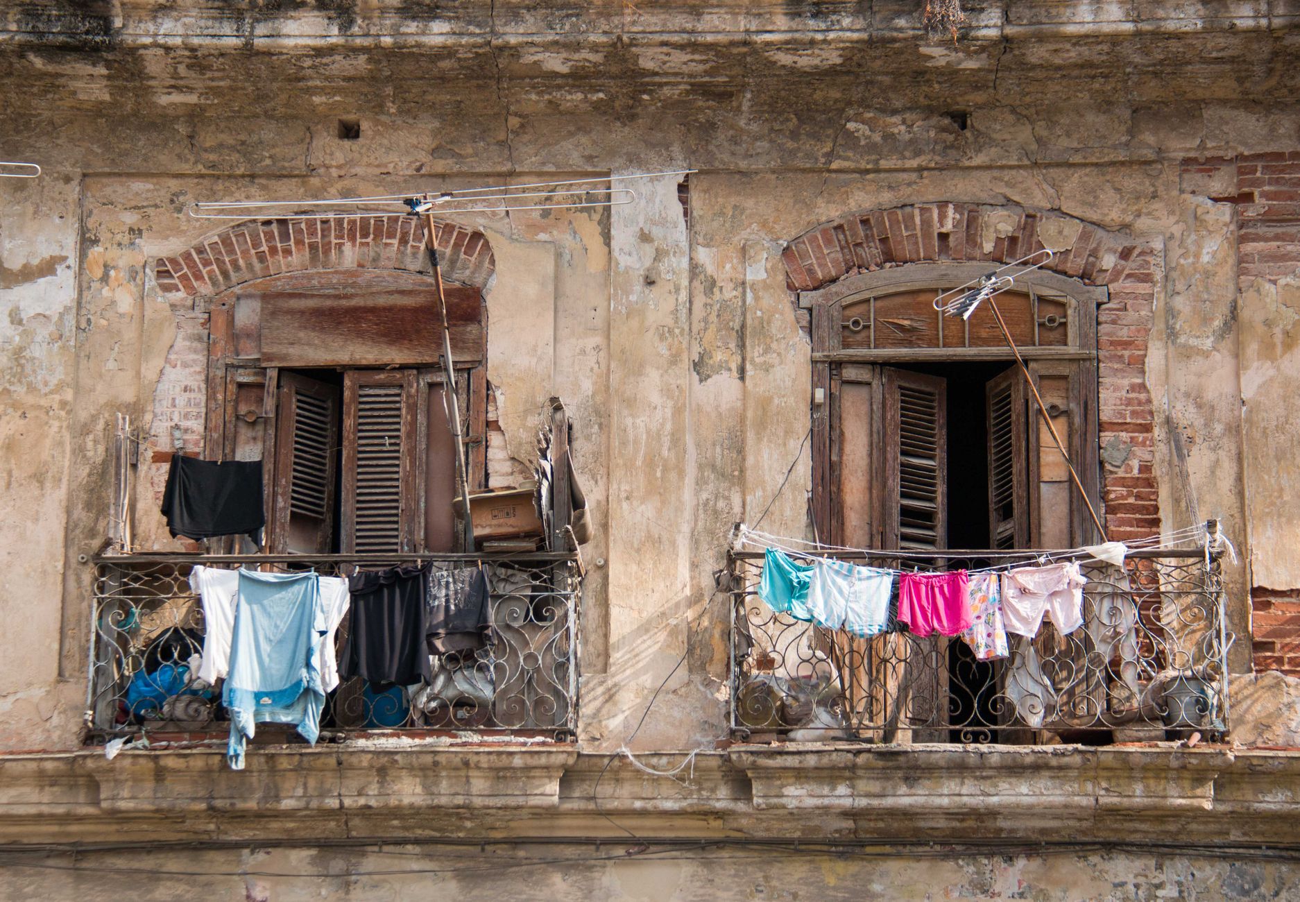 Laundry hanging from the peeling iron balconies of a decayed Havana apartment building