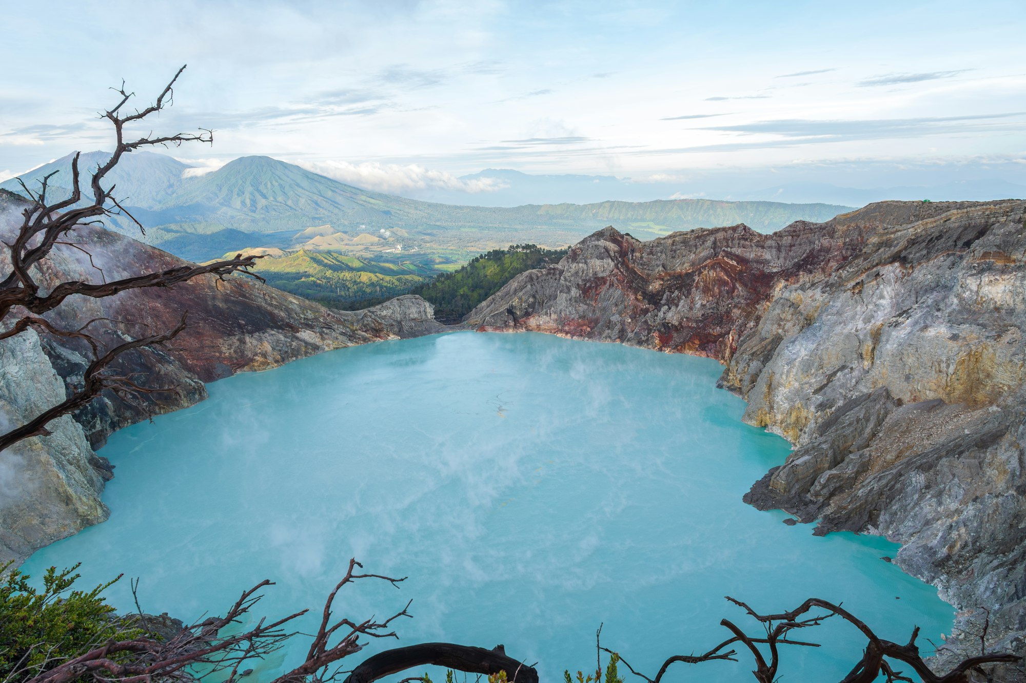 The turquoise acid crater lake of Kawah Ijen at dawn, ringed by bare volcanic walls