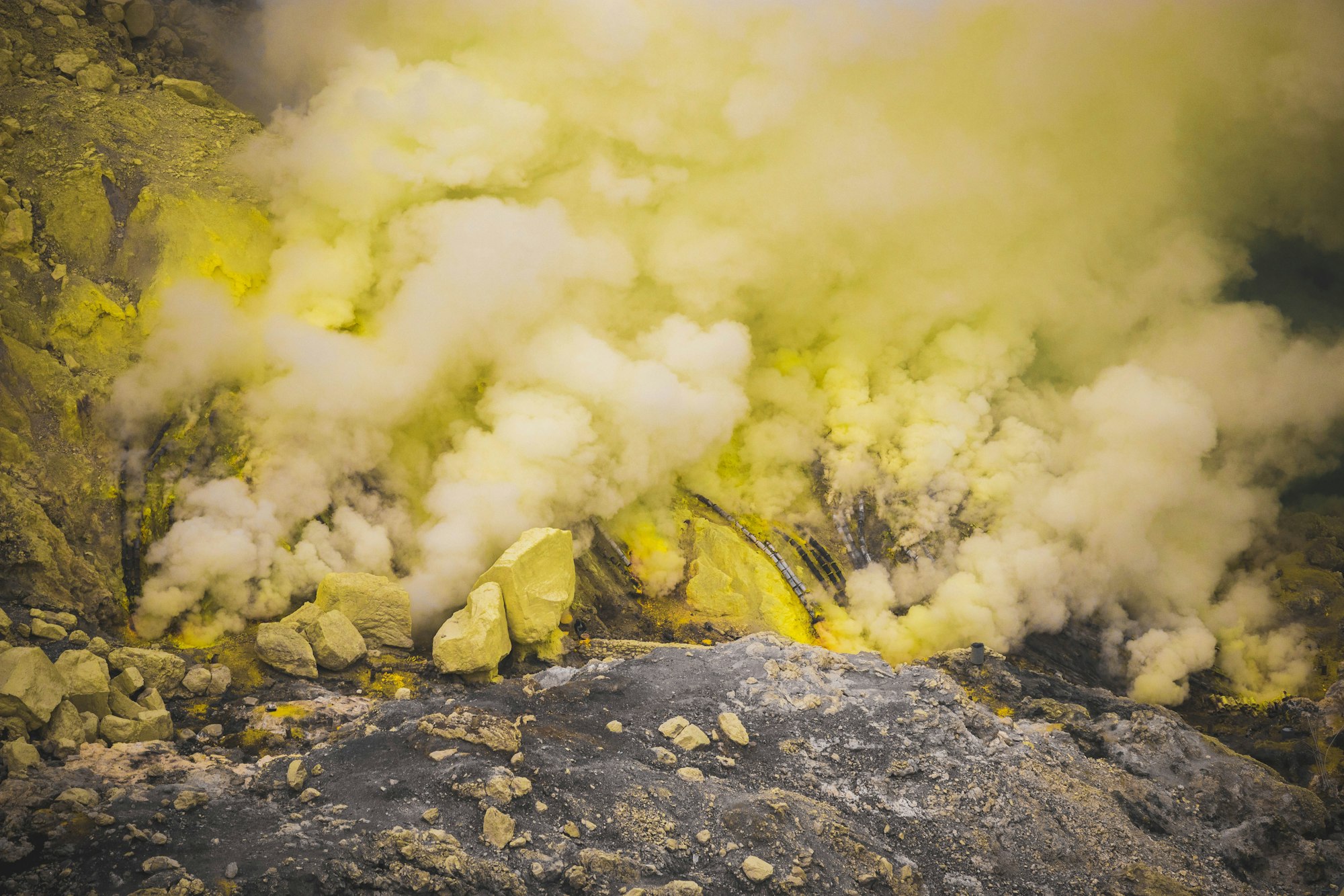 Yellow sulphur deposits and rising fumes at the mining vents of Kawah Ijen