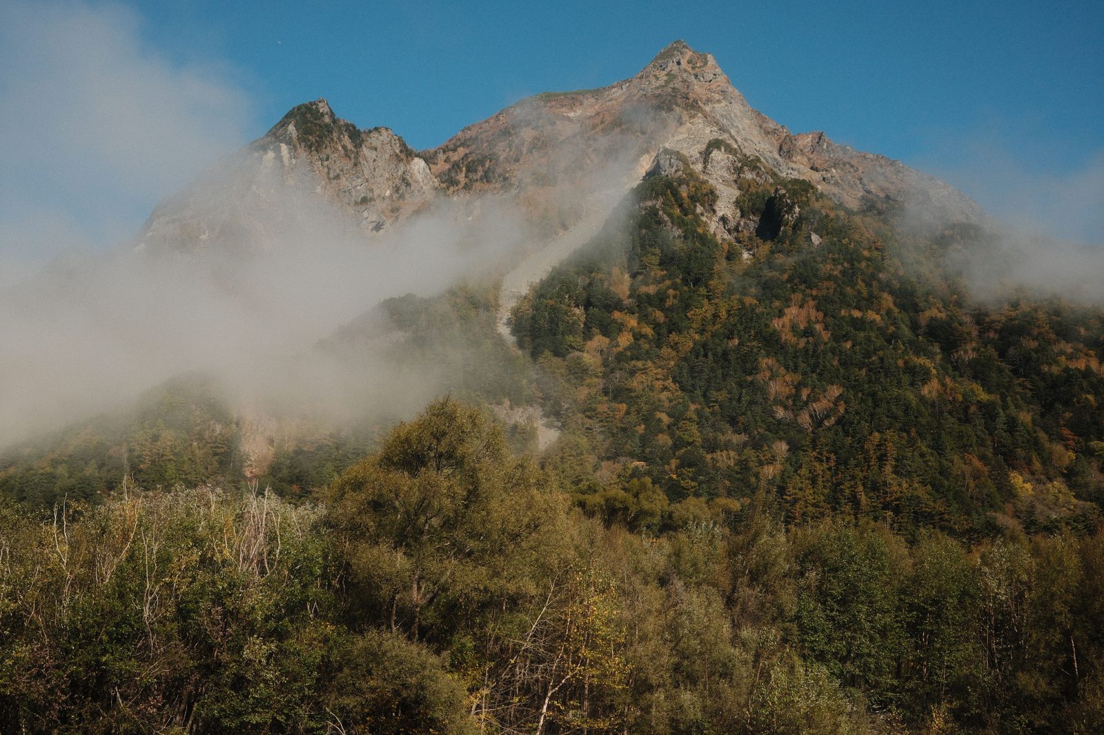 Fog lying across the wooded slopes of Mount Yake, an active volcano in the Japanese Alps, in autumn