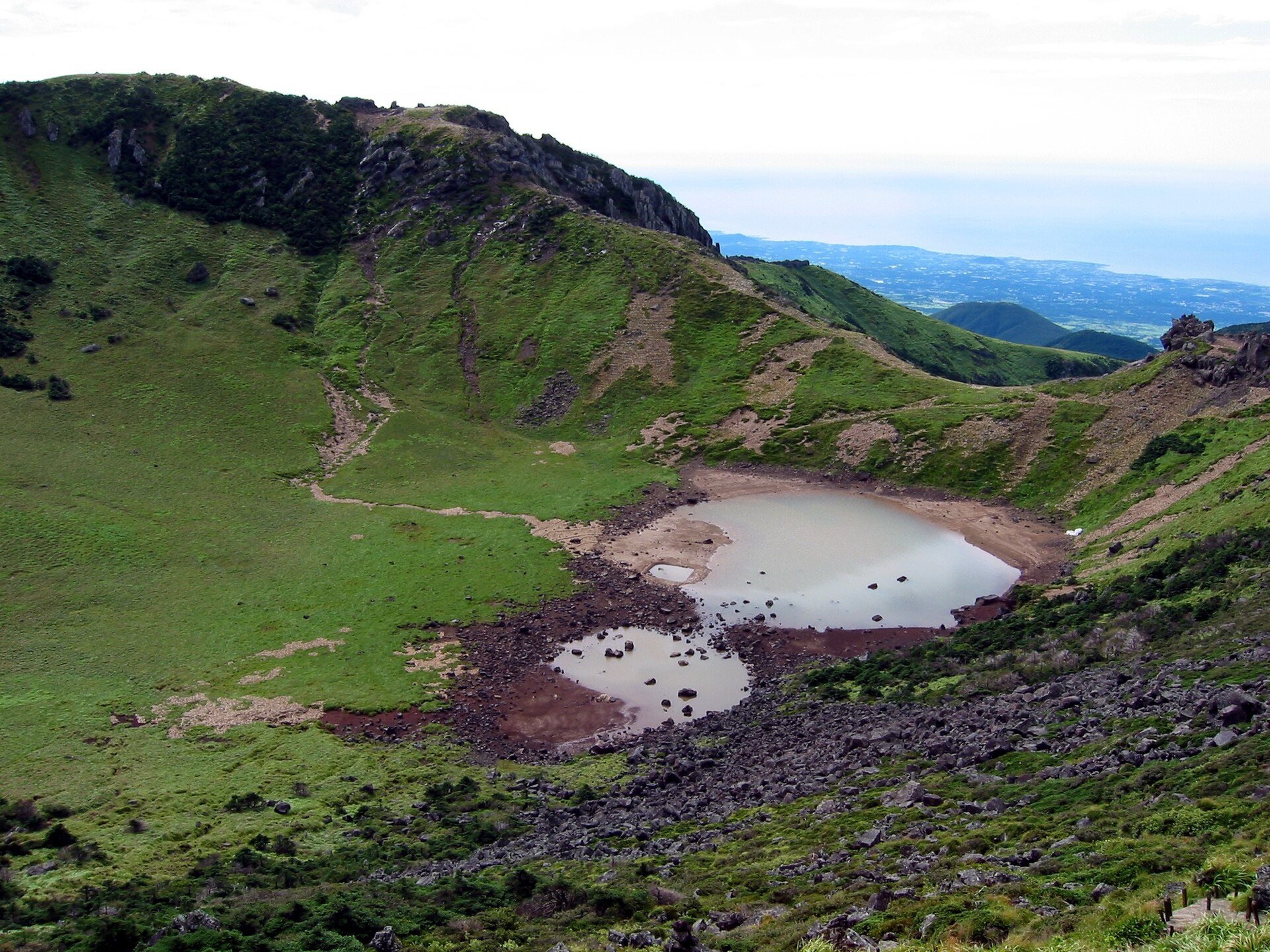 The Baengnokdam summit crater of Hallasan seen from the rim, its floor green with two shallow brown pools