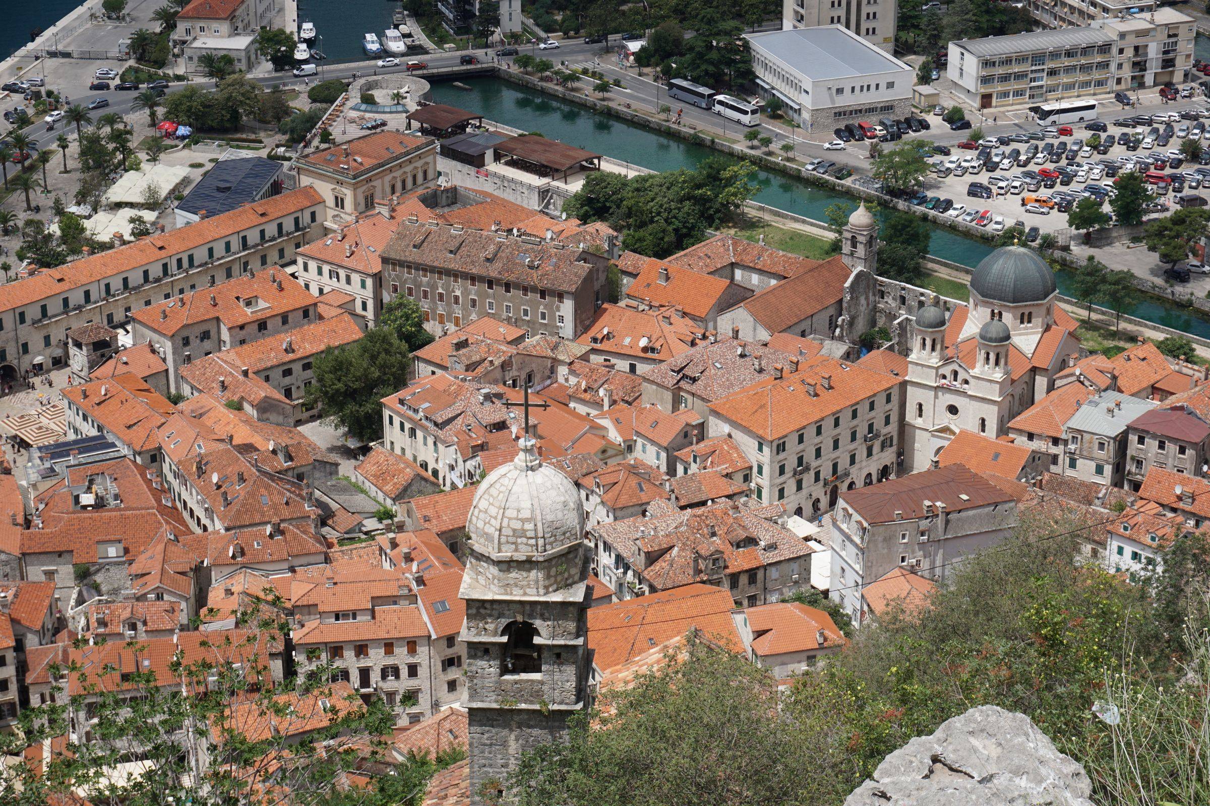 Kotor's old town from above, red roofs packed inside the walls and the domes of St Nicholas by the northern moat