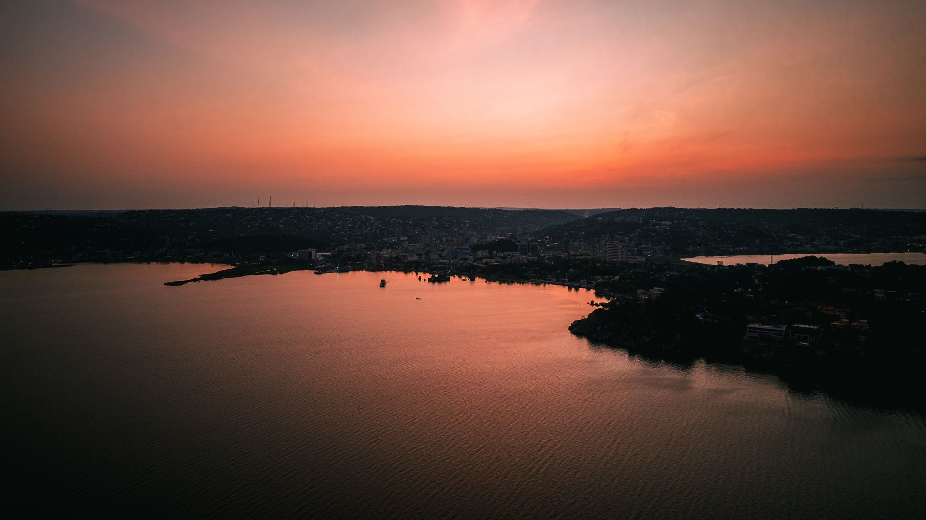 The wide expanse of Lake Victoria at dusk with a fishing boat