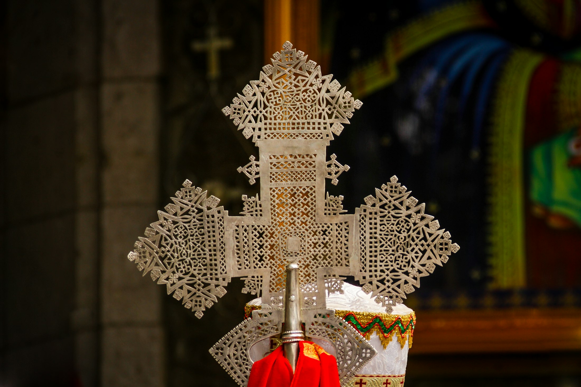 An Ethiopian Orthodox priest holding an ornate processional cross at Lalibela