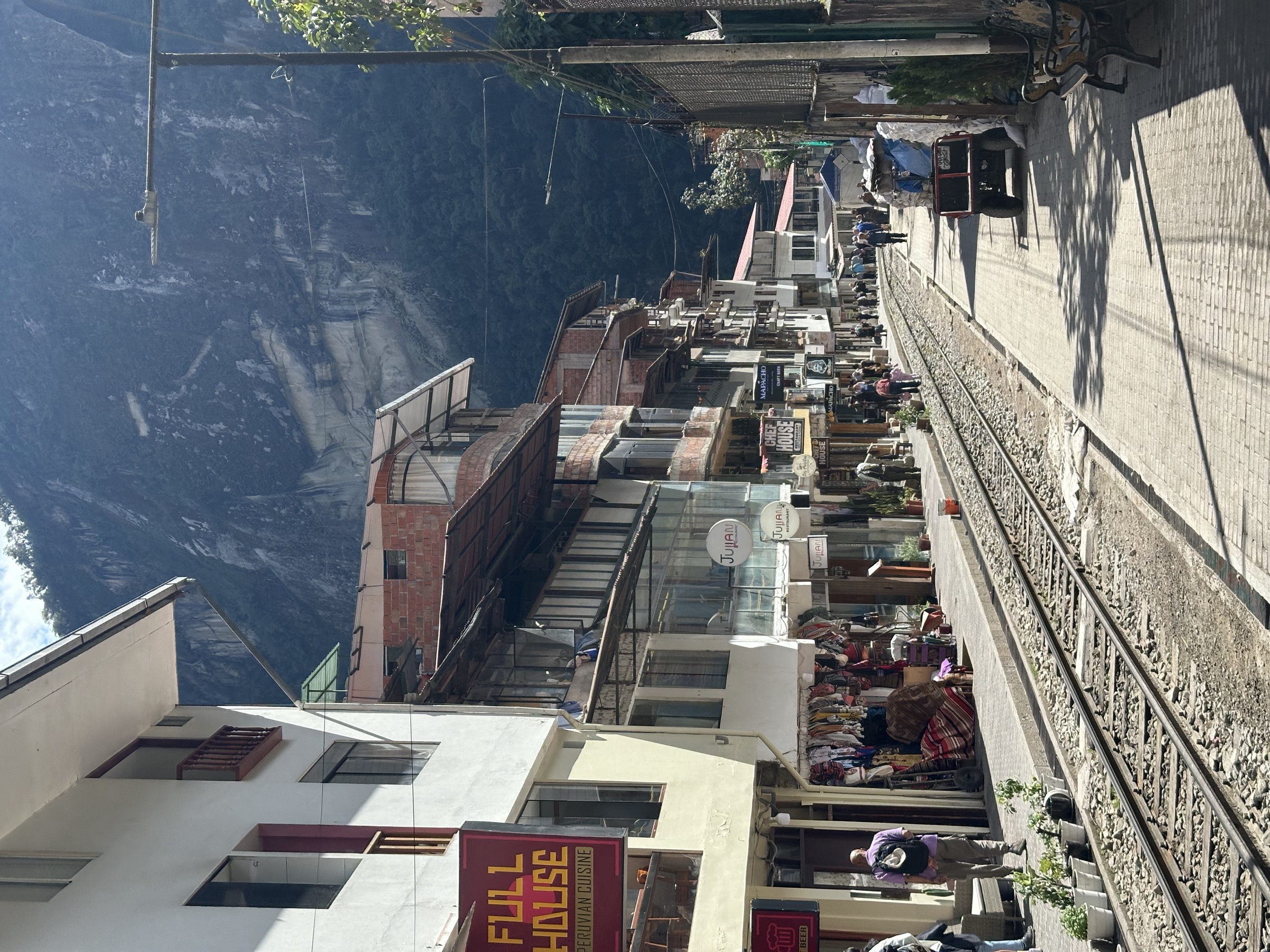 The main street of Aguas Calientes with shops and the railway tracks running down the middle of it