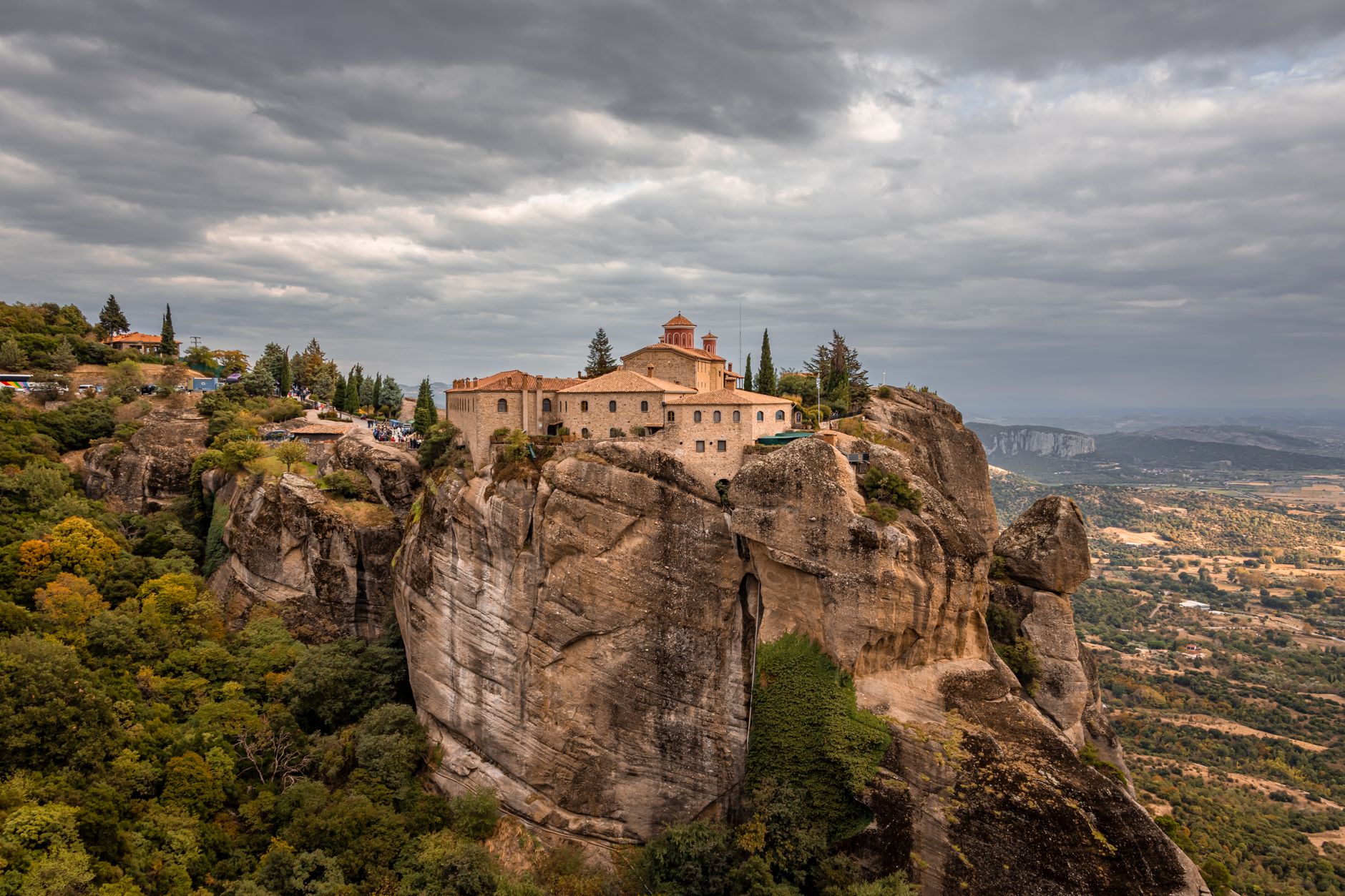 A Meteora monastery on the summit of a rock tower under a heavy grey sky