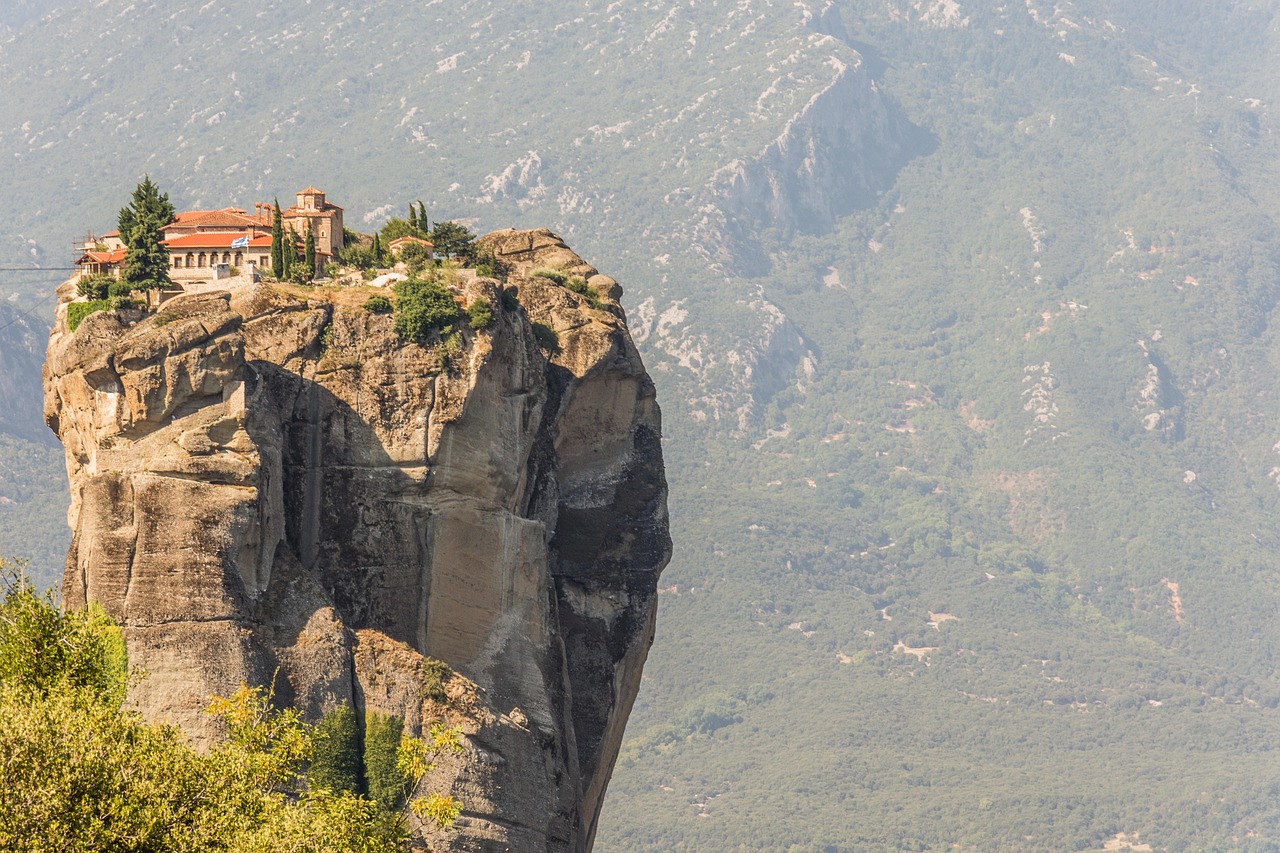 Holy Trinity monastery alone on an isolated rock tower with mountains behind
