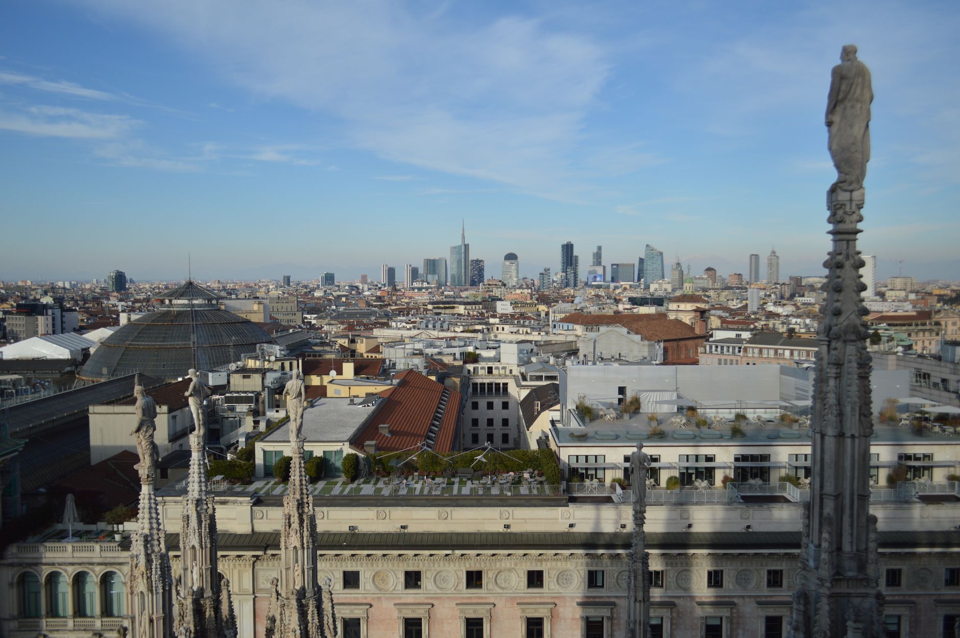 The spires of the Duomo roof with the Milan skyline behind them