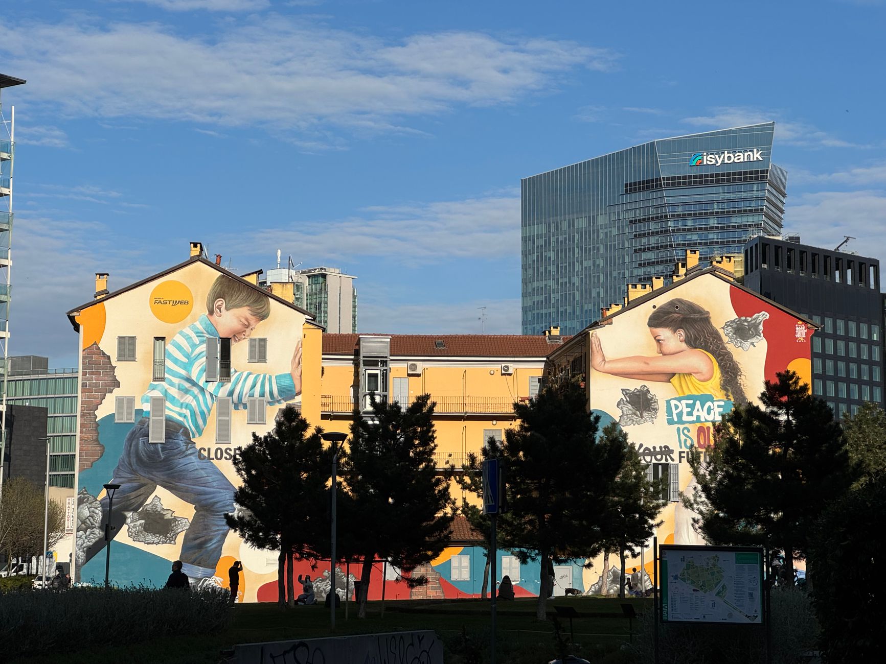 A painted housing block in Isola with the towers behind