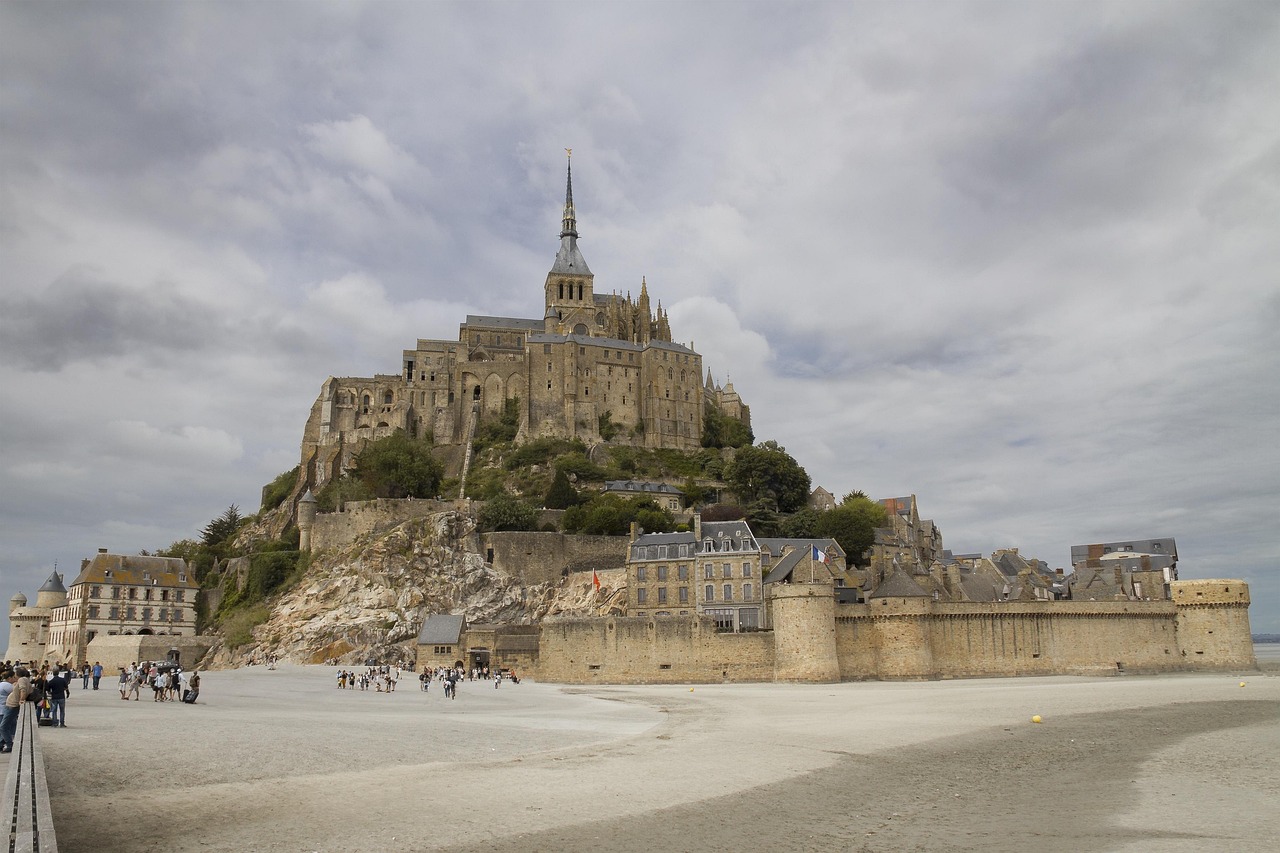 The walled village and ramparts of Mont-Saint-Michel seen from the sand at low tide