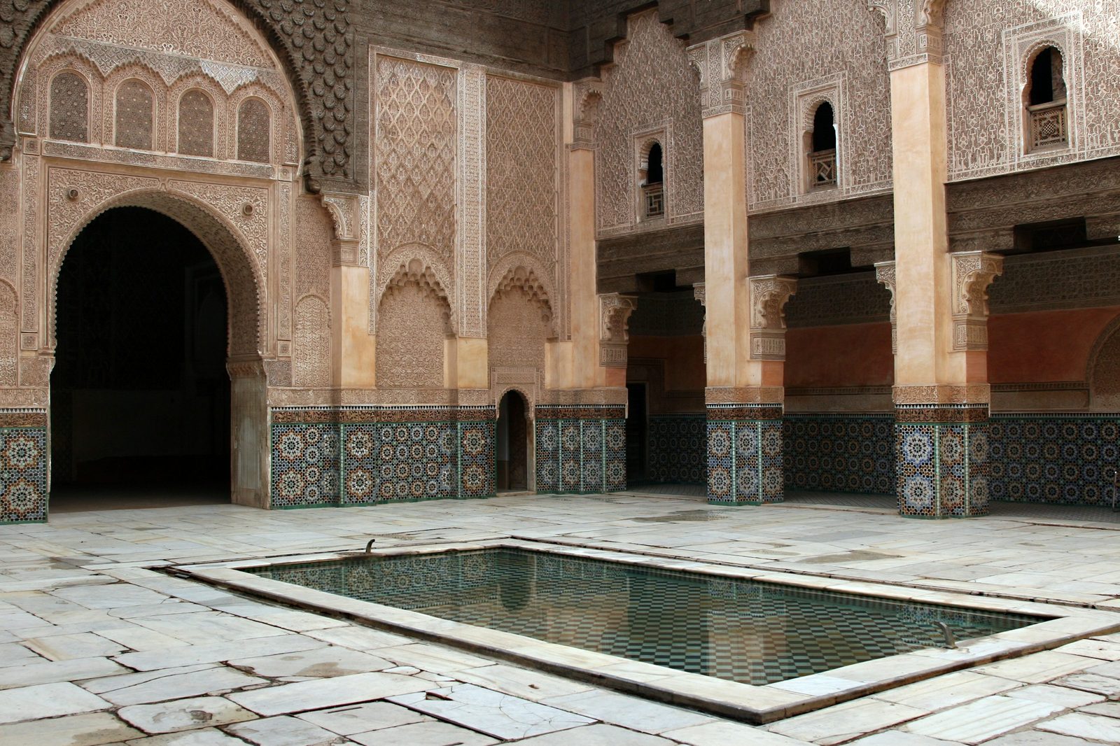 The courtyard of the Ben Youssef Madrasa in Marrakesh, with its central pool, carved cedar, stucco and zellige tilework