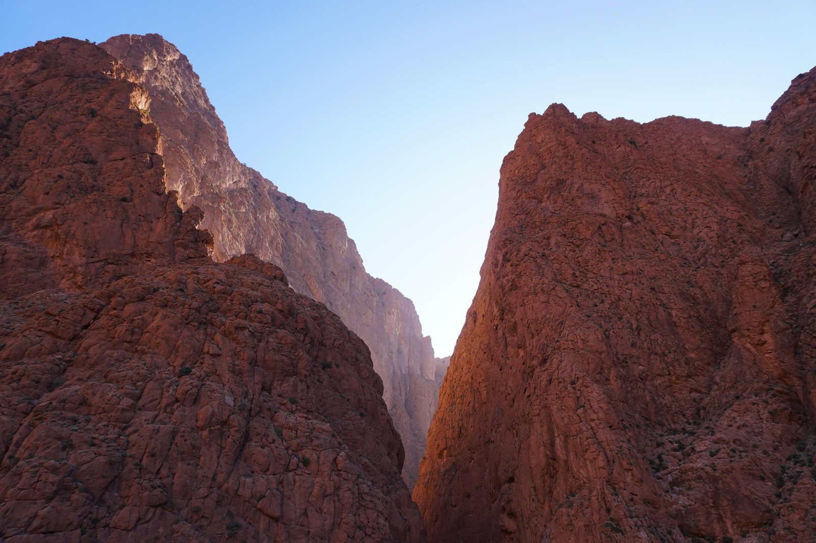 Red rock cliffs of a gorge in the Drâa-Tafilalet region of Morocco against a blue sky