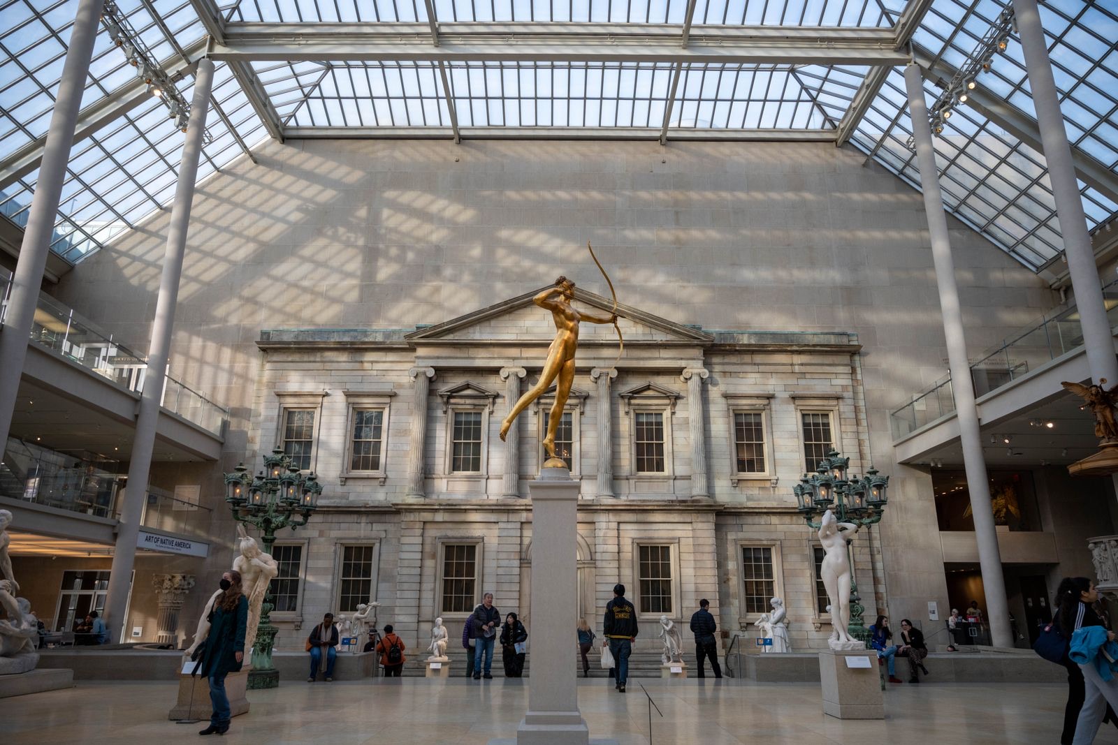 The glass-roofed Engelhard Court with a gilded statue on a column in front of a marble bank facade