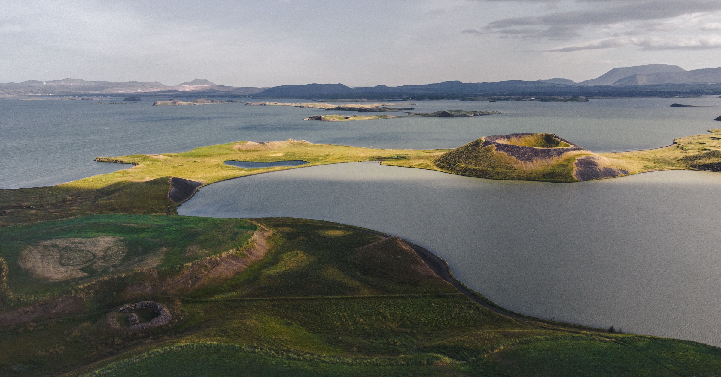 Lake Mývatn from the air, its shore pocked with small green craters