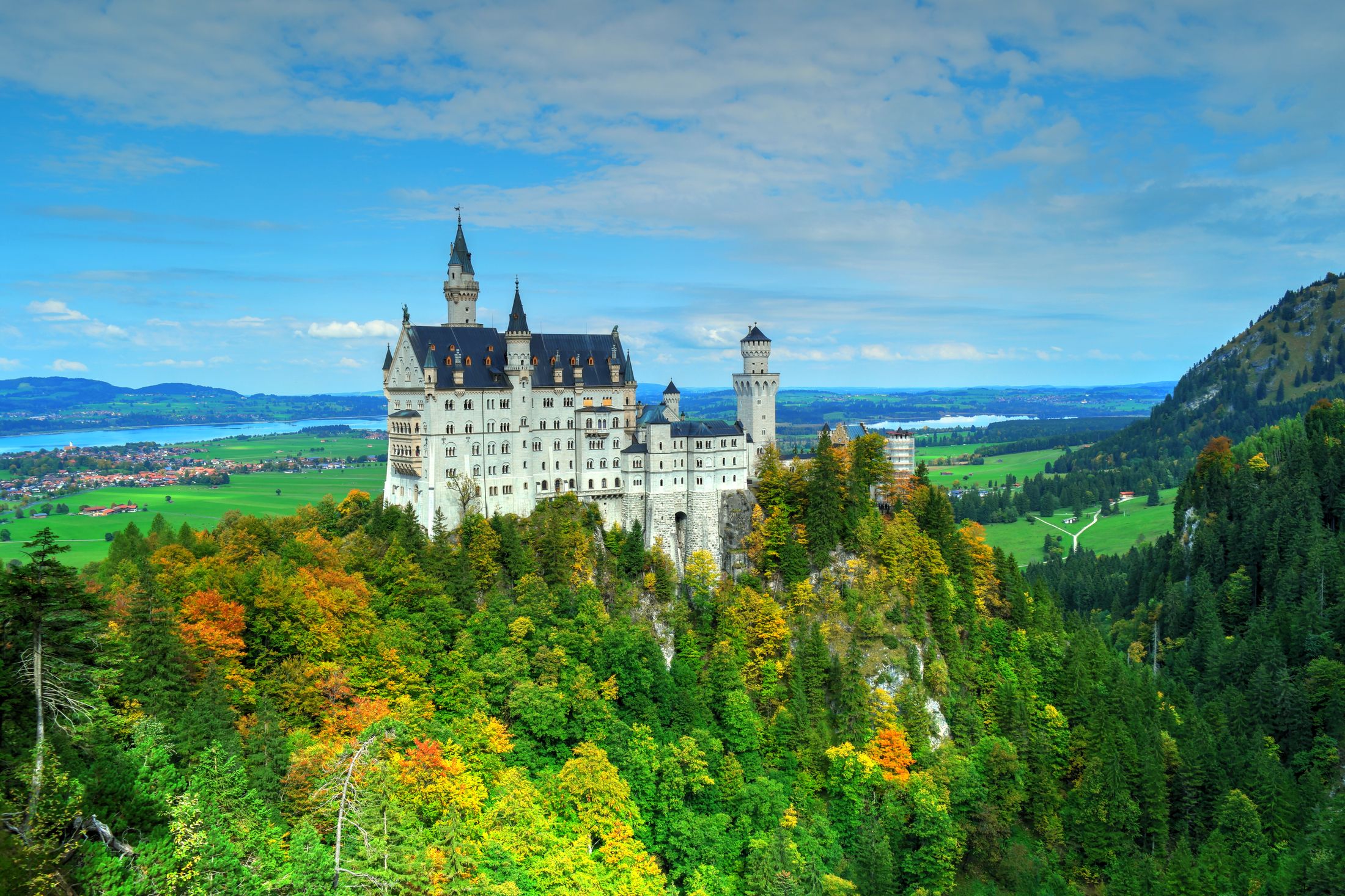 Neuschwanstein on its crag above the Allgau plain and lakes, the Bavarian Alps around it