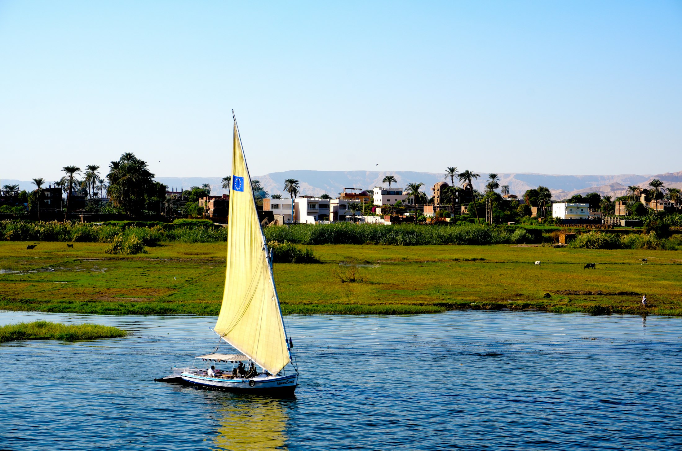 A traditional white-sailed felucca on the Nile near Aswan